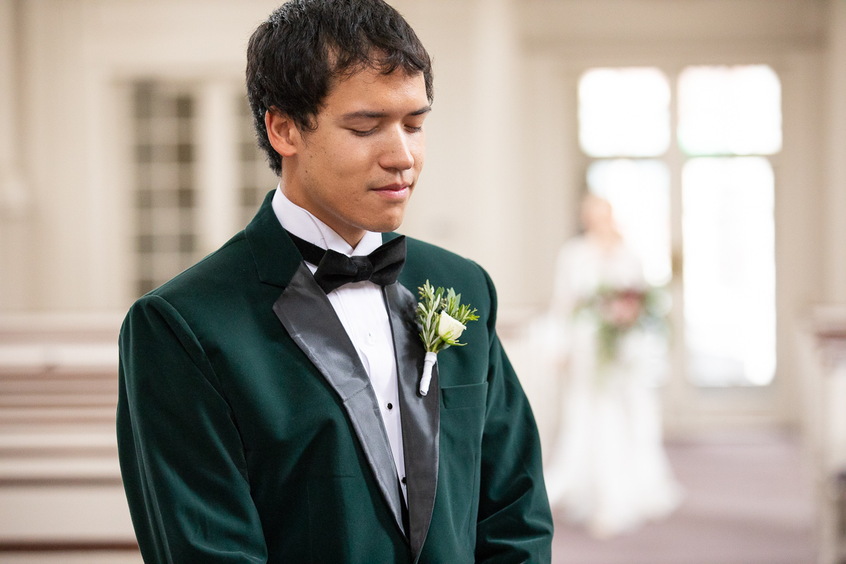 Groom waiting for bride during first look.
