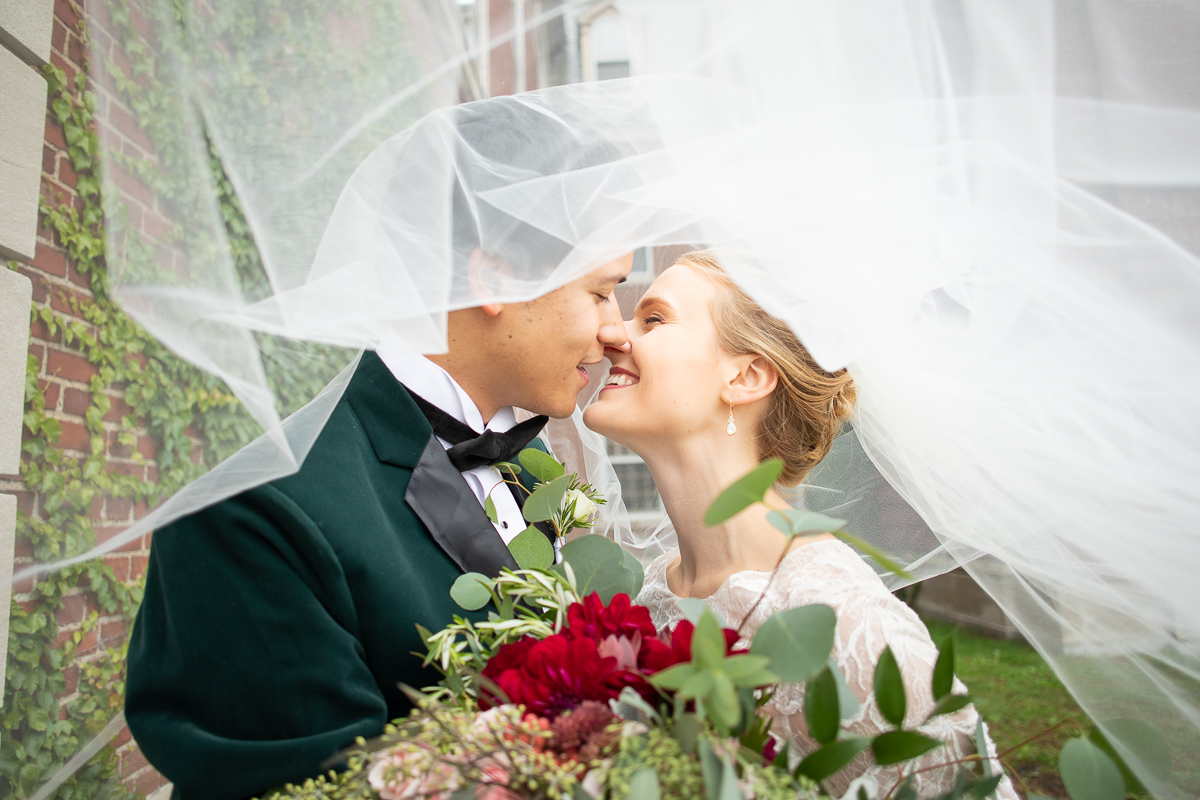 Bride and groom under veil.