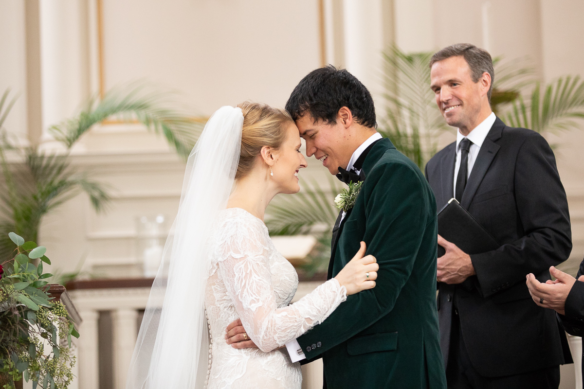 Bride and groom smiling after first kiss.