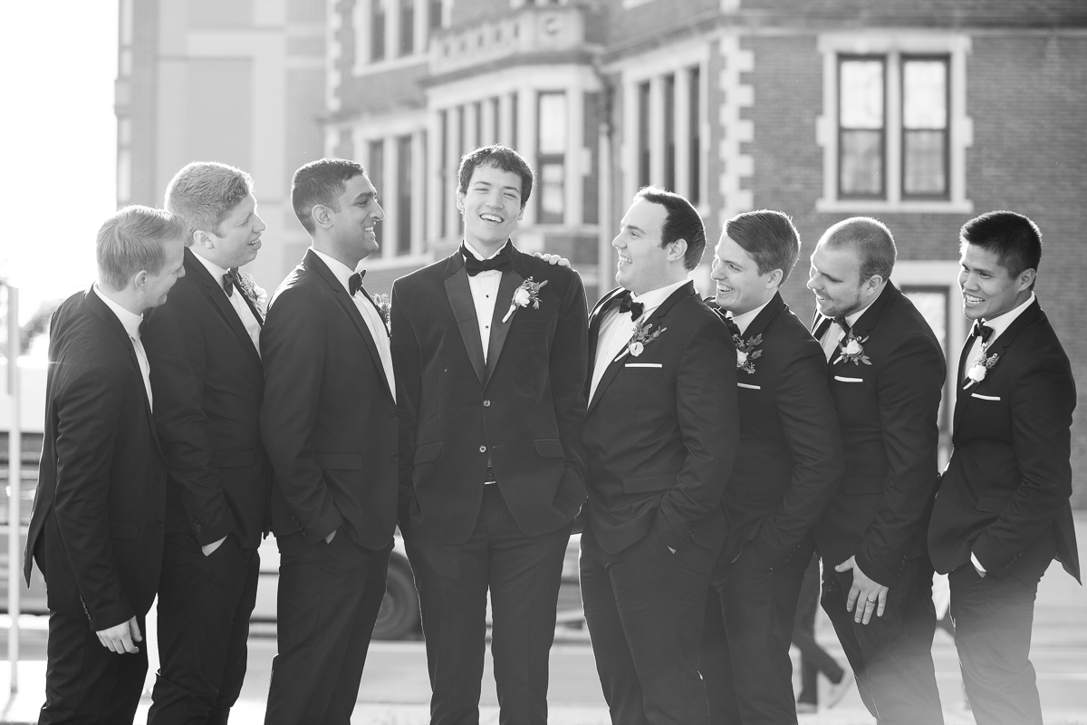 Groom and groomsmen laughing during Boston wedding.
