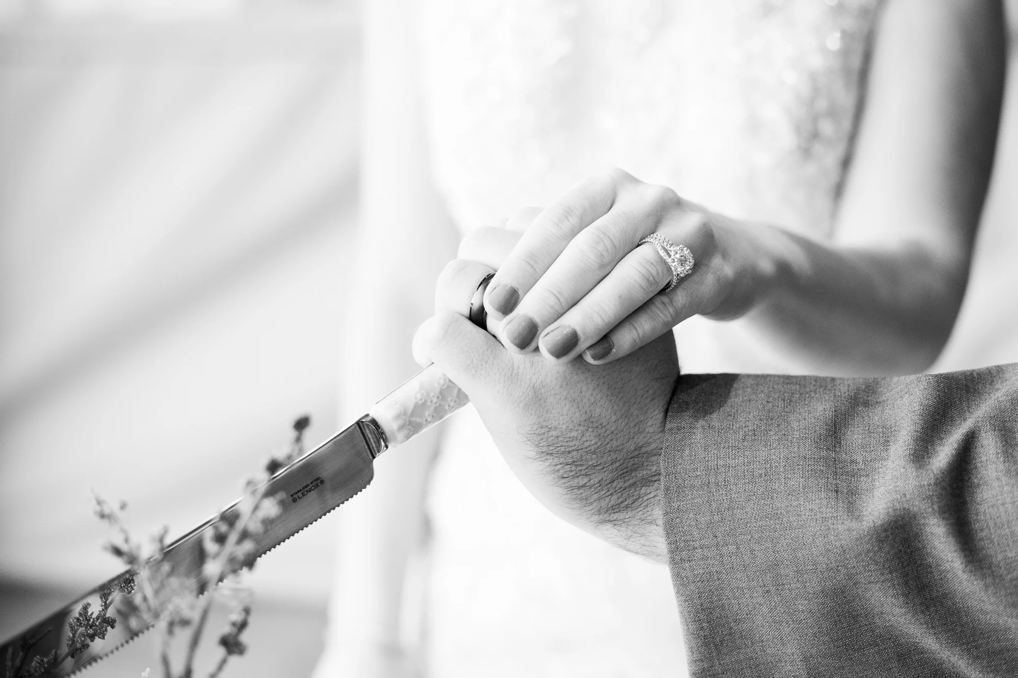 Bride and groom cutting Nizhoni Bakery wedding cake with Kimpel’s Jewelers wedding rings.