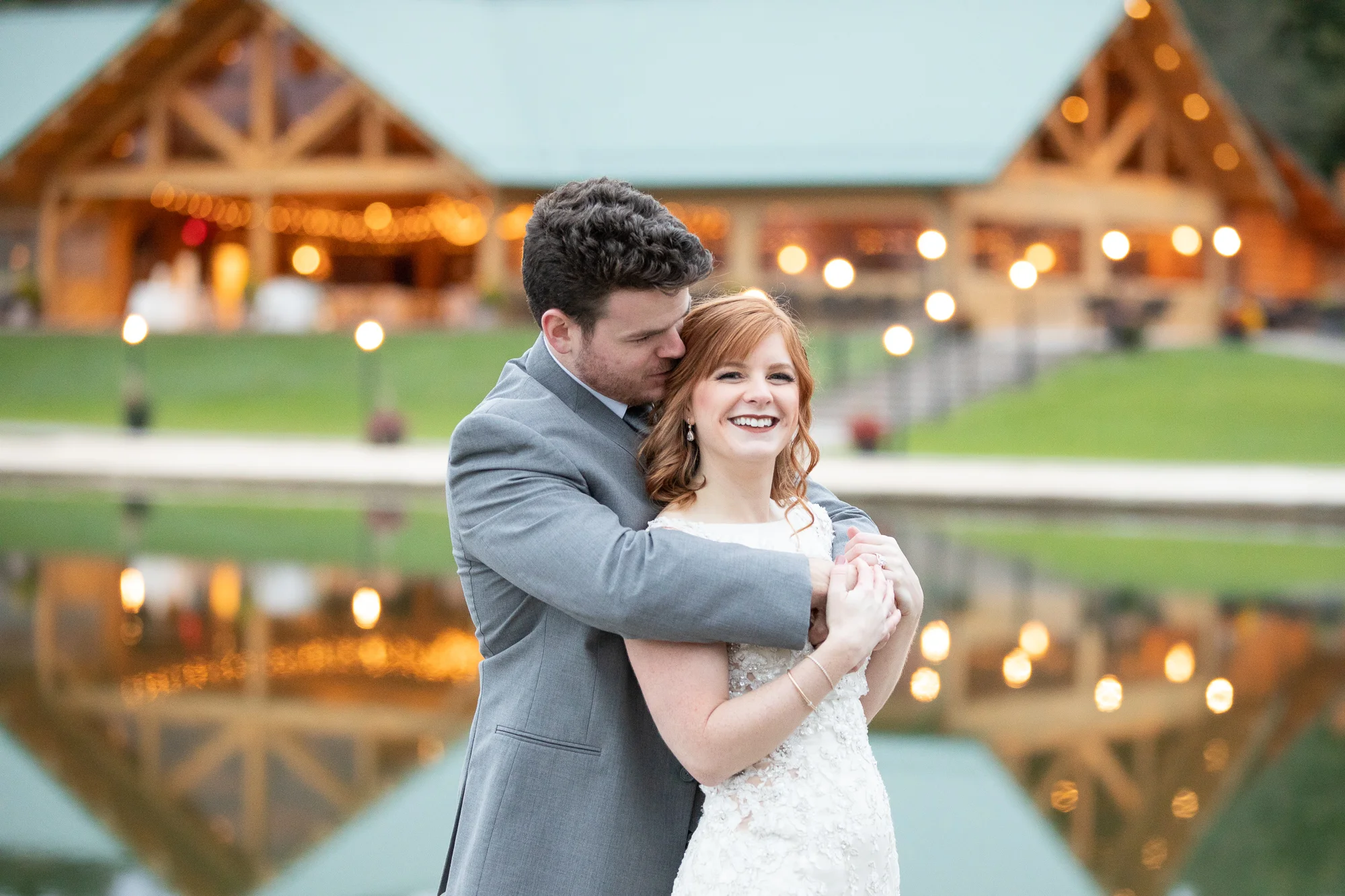 Bride and groom smiling at The Gathering Place at Darlington Lake. Cable Creations tuxedo. Bridal Elegance wedding gown. Hair by Ashley’s Mobile Studio.
