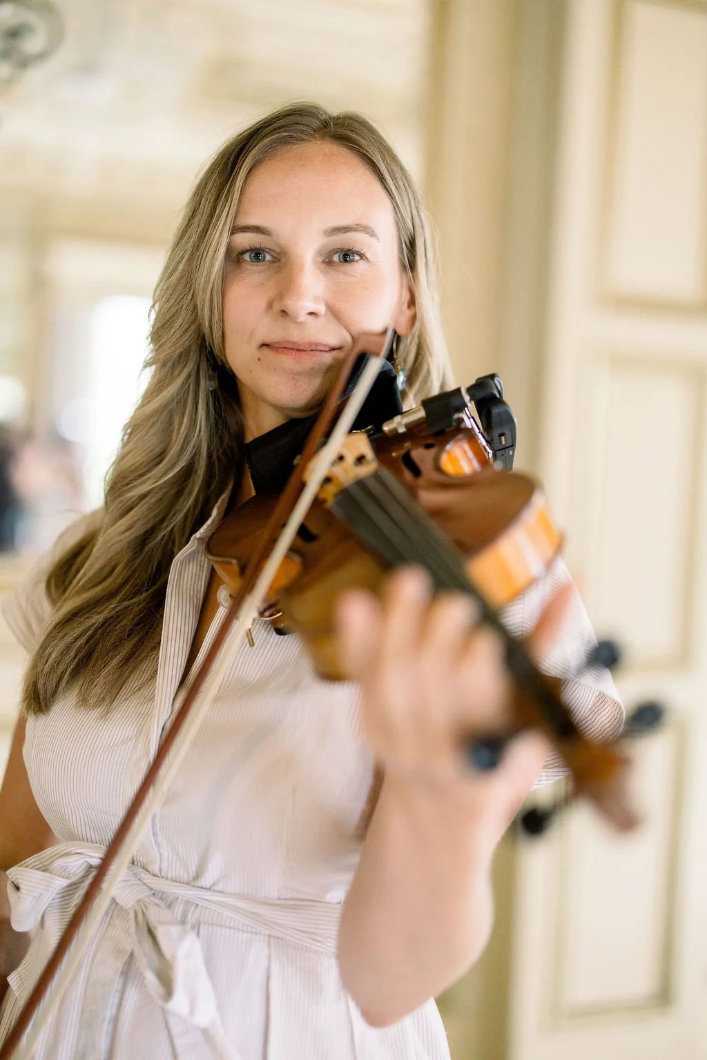 close up violinist in a white and beige dress performing at the Kentucky Castle