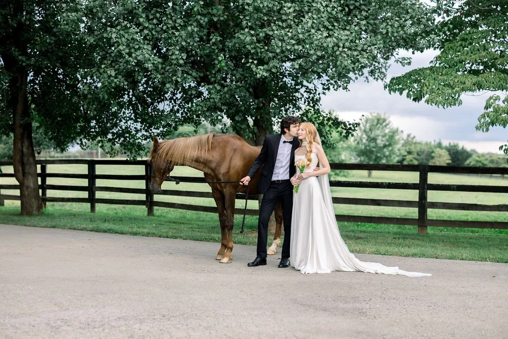 a bride and groom with a black horse at Kentucky Castle in Lexington
