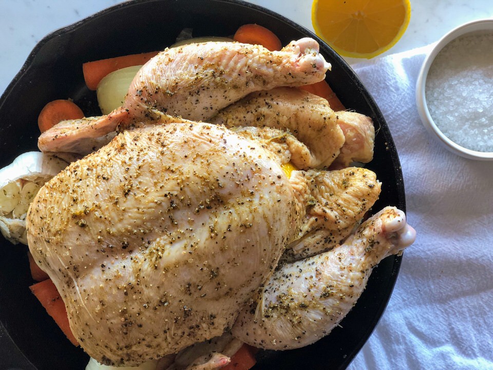Uncooked Whole Cast-Iron Chicken with Carrots, Onions, and Garlic