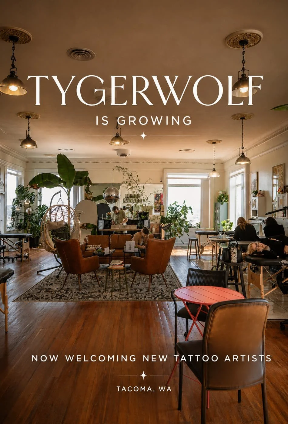 tygerwolf tattoo studio, dj playing, people getting inked on beds, a women sits on the couch in the middle of the studio