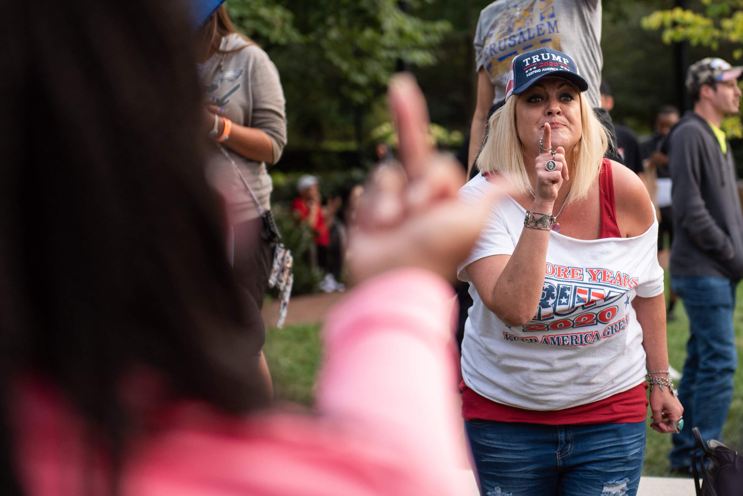   A person raises their middle finger at a Trump supporter as they confront protesters on Sept. 15, 2021. Protesters and counter-protesters gathered outside the Constitution Center in Philadelphia where President Donald Trump held a townhall.   
