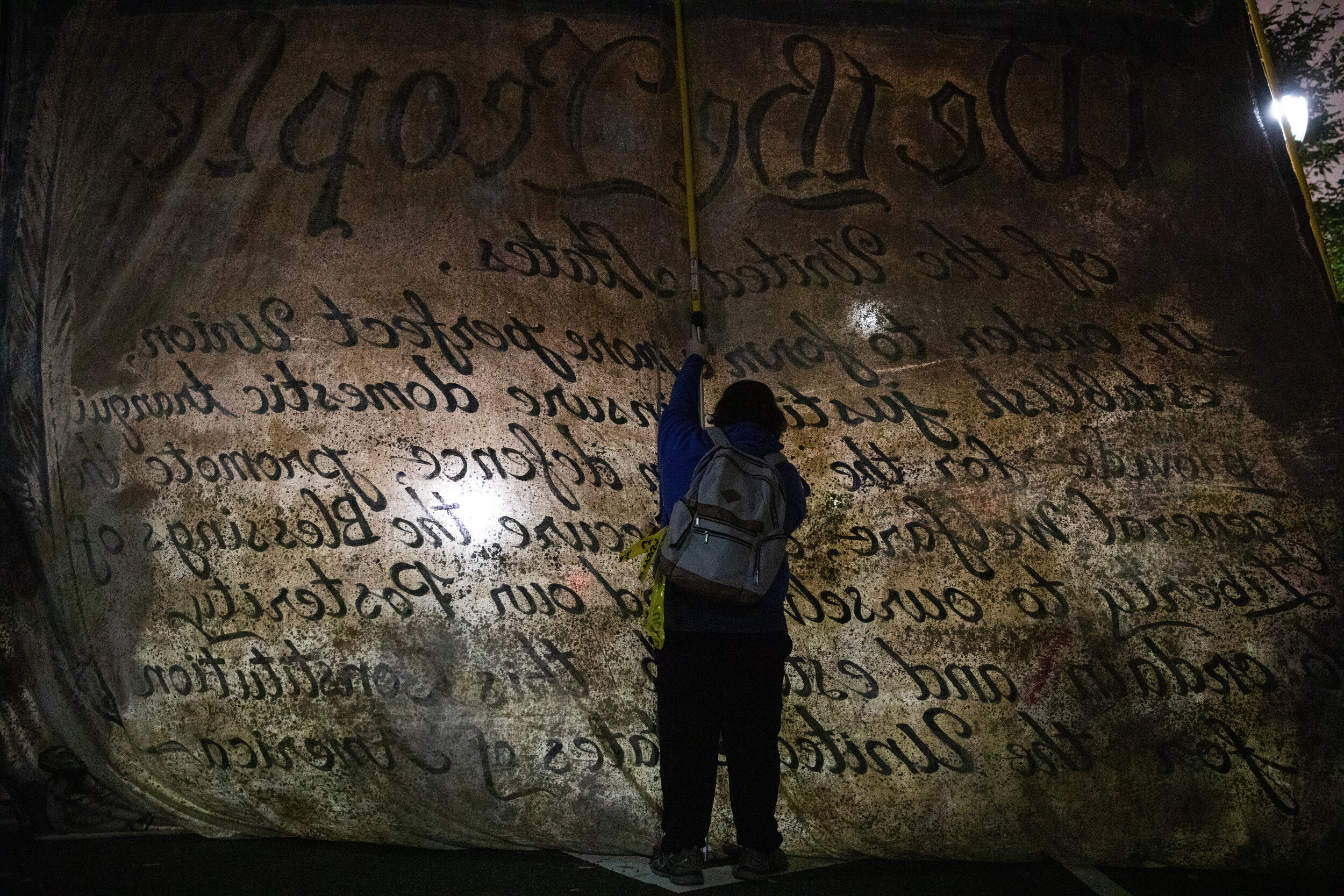  A person holds up a large recreation of the U.S. Constitution during a rally outside of the Pennsylvania Convention Center in Philadelphia as votes were being counted for the 2020 presidential election.    