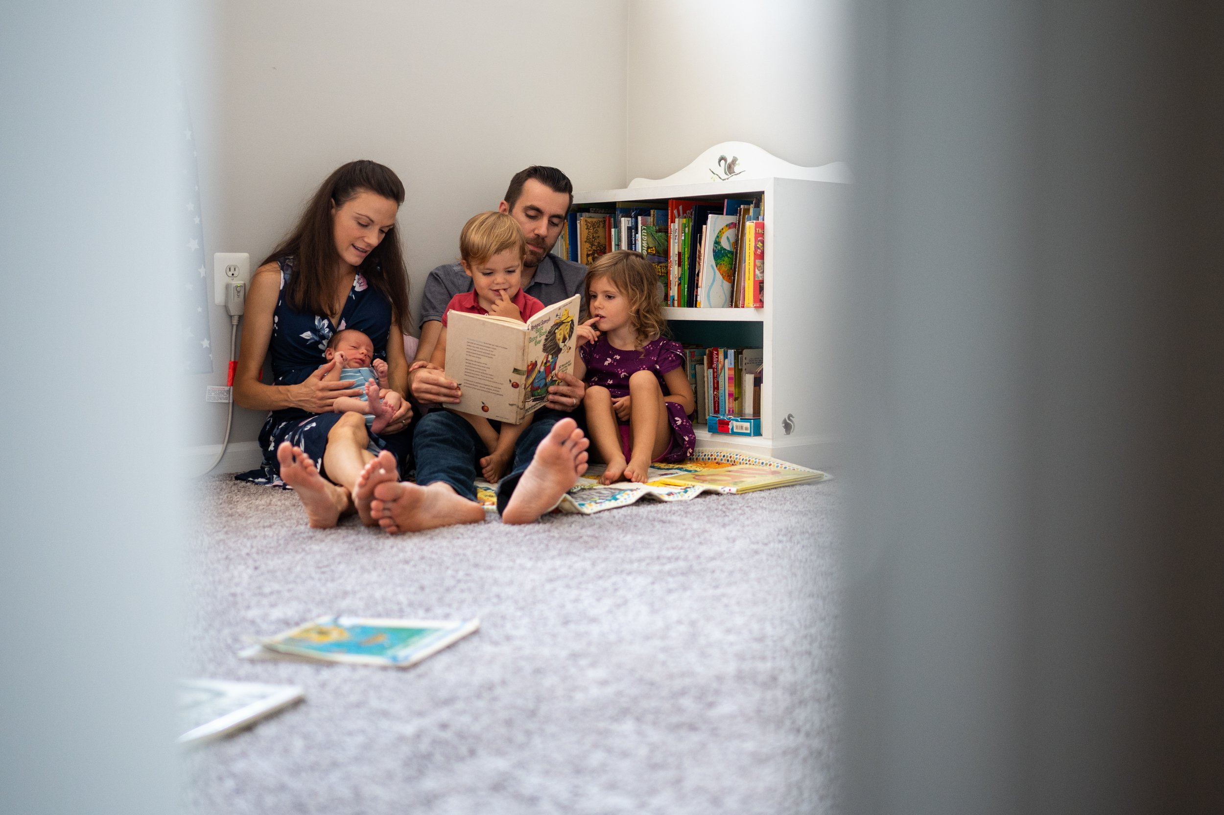   Megan Carroll (left) and Jesse Carroll (center) sit and read with their children in their home in Gloucester City, N.J. on Aug. 27, 2020.   