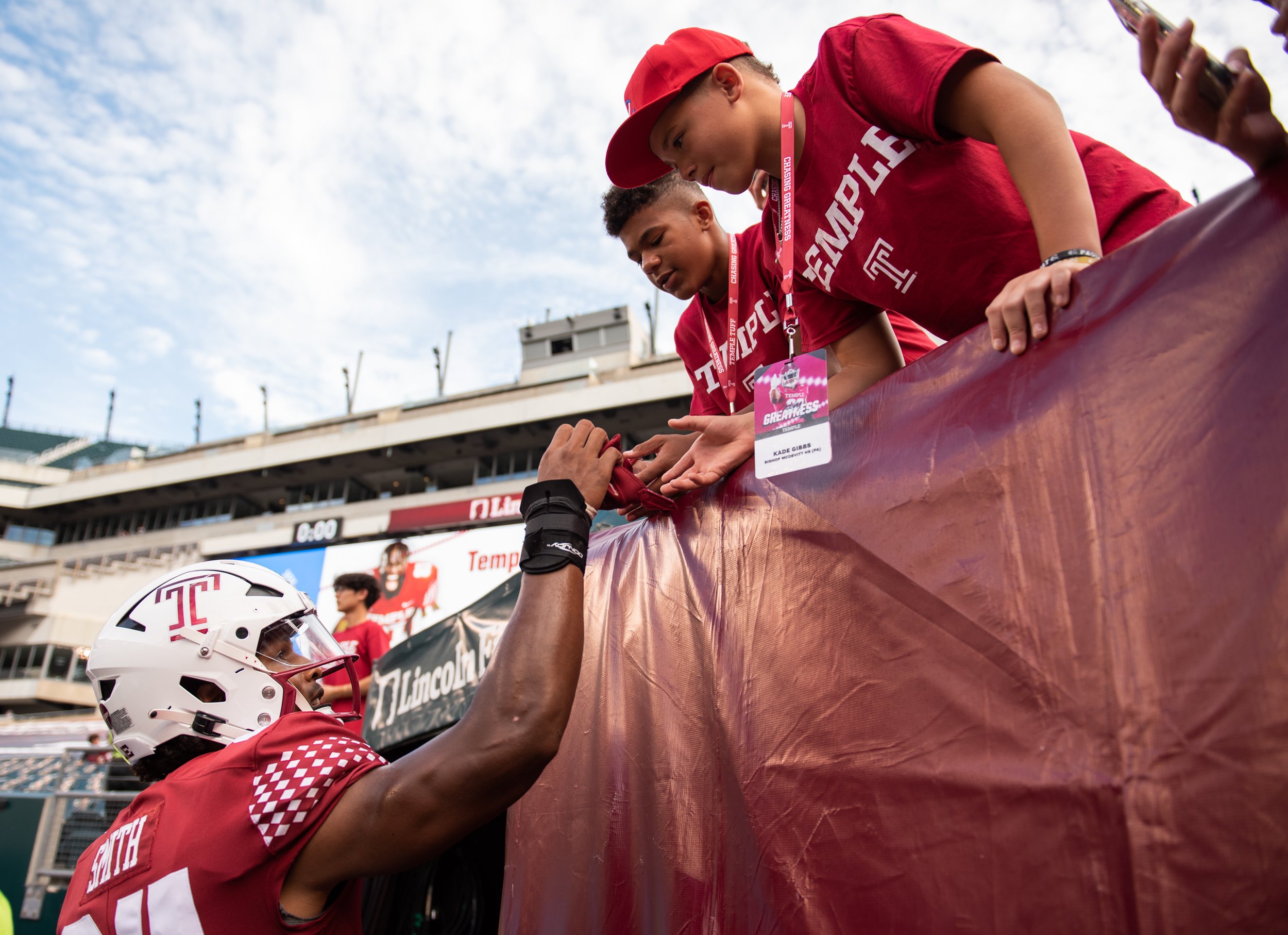   Jordan Smith, tight end for the Temple Owls, hands his gloves to fans after the game against Lafayette College on Saturday, Sept. 10, 2022. The Temple Owls won 30-14.   