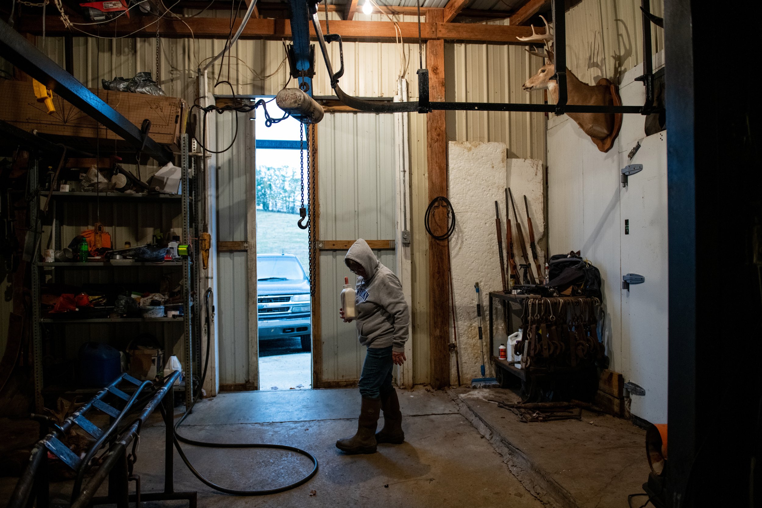  Judy Northcutt, a resident of Cynthiana, Ky., stands in her garage and gets ready to bottle-feed her calf at a nearby farm on October 31, 2019.  