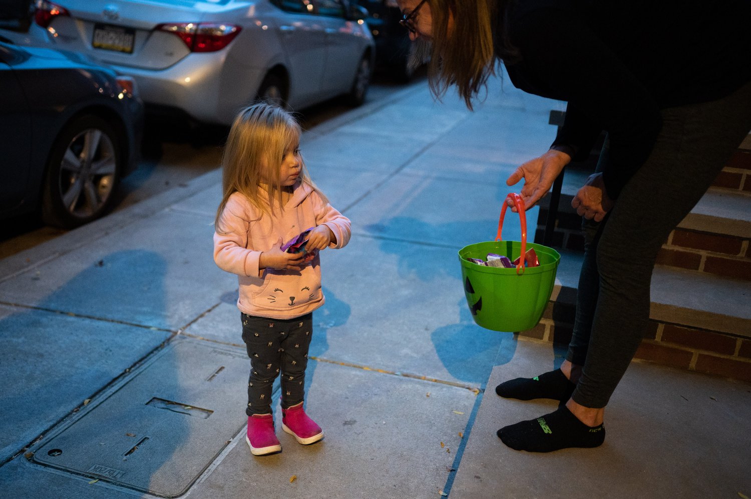   A Northern Liberties resident gives Sarra Bihun candy on Wednesday, Oct. 31, 2022. It is the first time the Bihuns have experienced Halloween as it is not celebrated in Ukraine.  