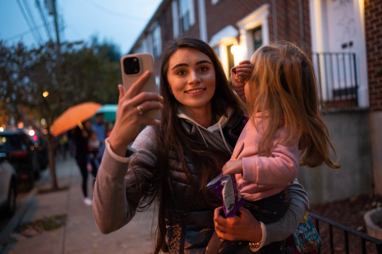   Yuliia Bihun records a video of trick-or-treaters while walking around Northern Liberties on Wednesday, Oct. 31, 2022. It is her and Sarra's first time experiencing Halloween.   