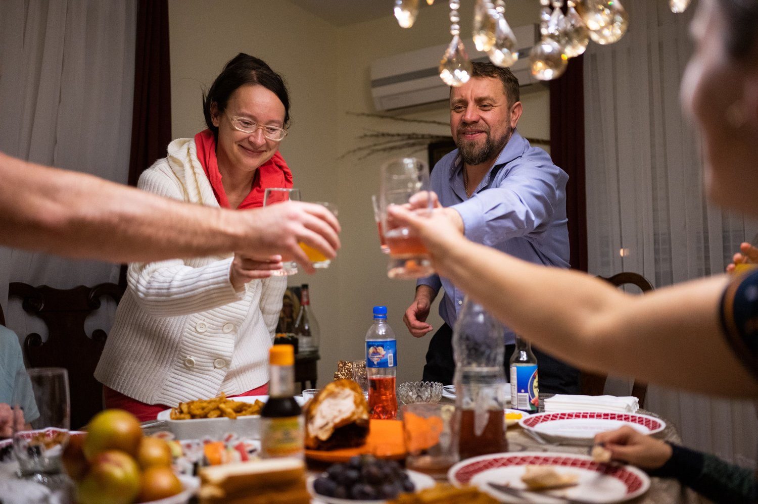   Veronica Matviienko (left) and Bishop Luke Zhoba (right) cheer before dinner on Wednesday, Oct. 31, 2022.  