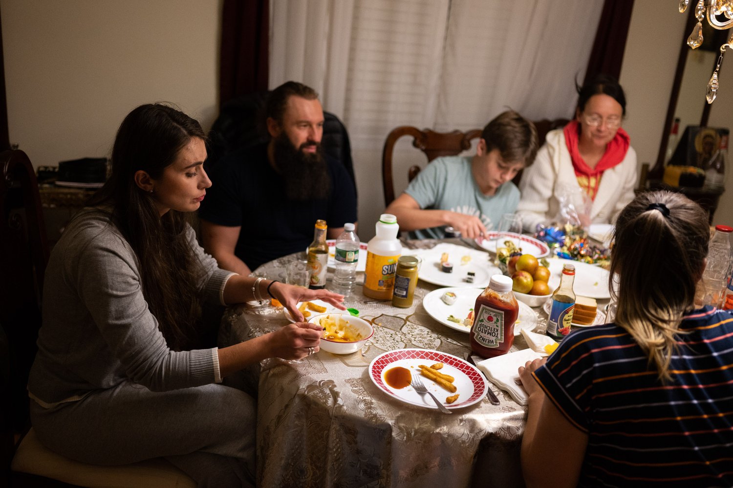   Yuliia Bihun (left) eats at the dinner table with the rest of the Ukrainians she lives with at Saint Nicholas's Church.  
