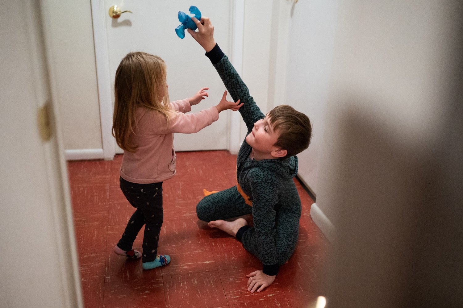   Sarra Bihun (left) and Ihor Pasichniak (right) play together in the downstairs hallway of their house.   