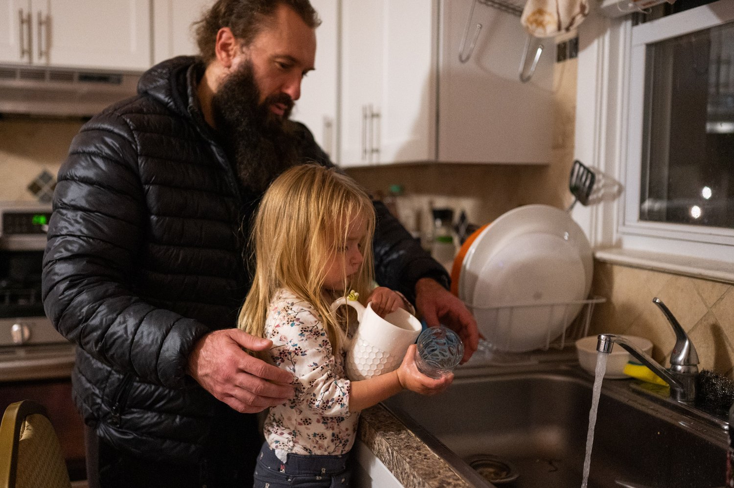   Dmitriy Bihun helps his niece Sarra Bihun wash cups after dinner on Wednesday, Oct. 31, 2022.  