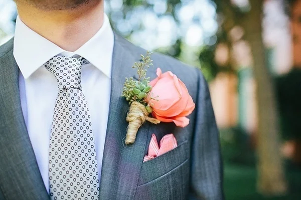 Dapper photo of the groom's peach boutonniere and printed tie