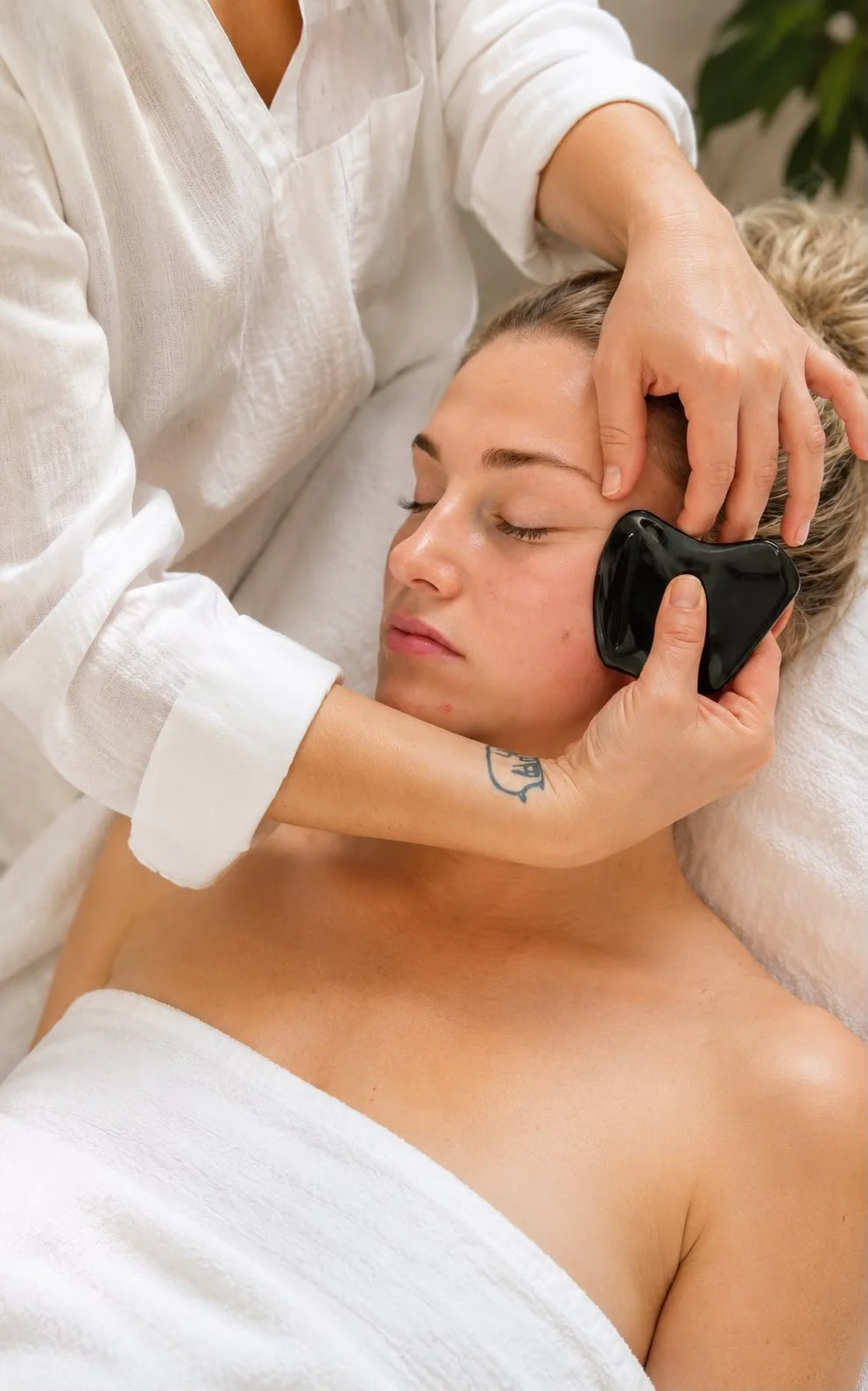 an image of a gua sha facial treatment being performed by a professional skin care therapist
