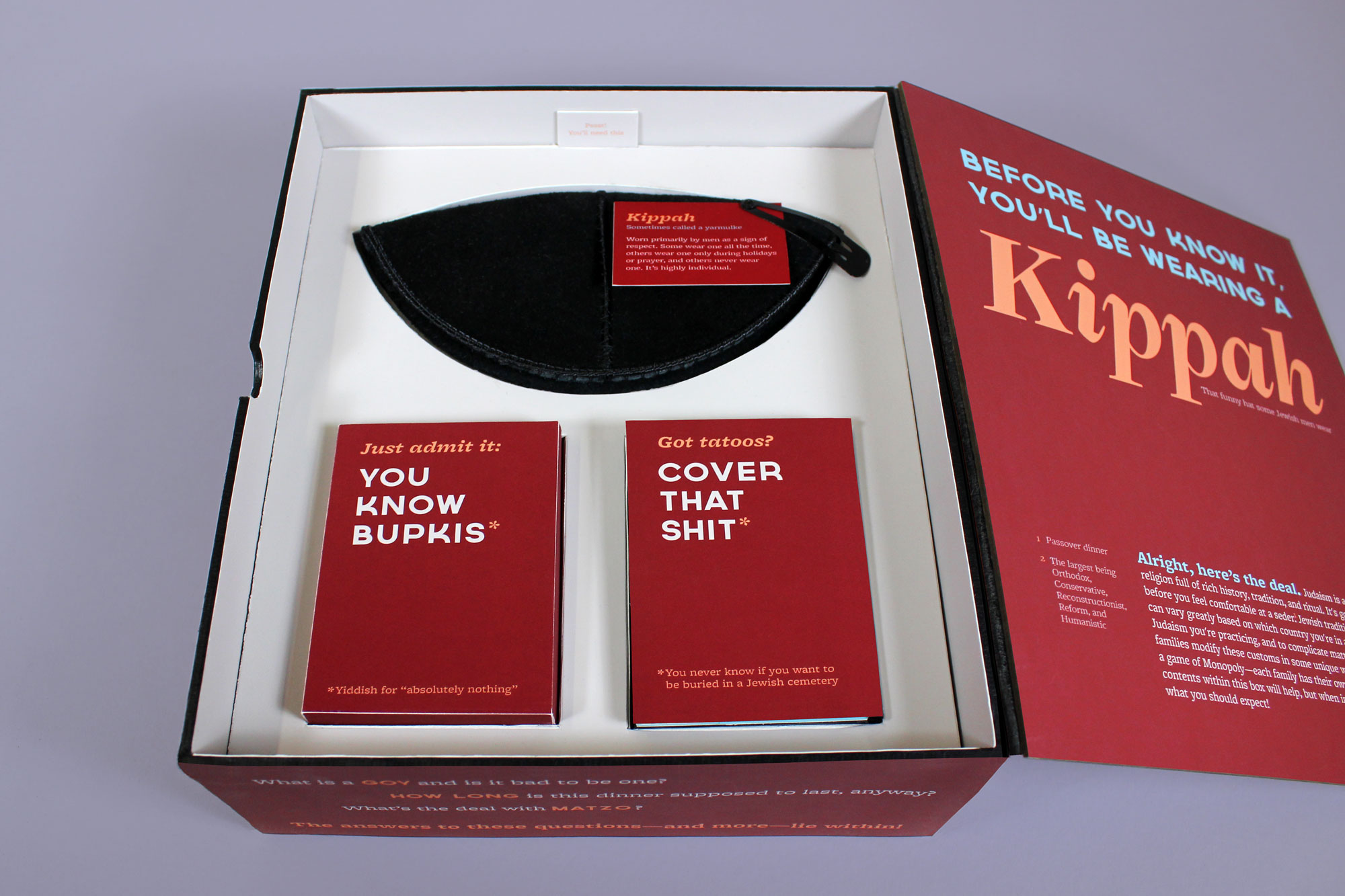 Once the insert is lifted, the viewer is presented with a kippah (along with instructions on how and when to wear it), a deck of flashcards, and tattoo cover-up in various skin tones.