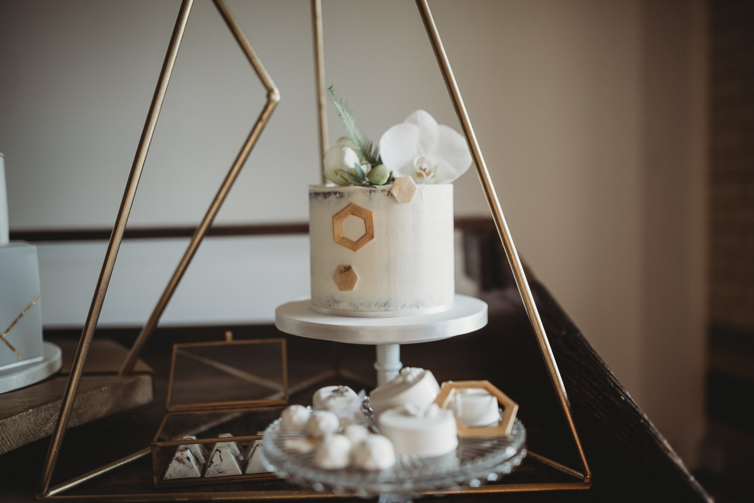  Close up of geometric wedding cake by Storeybook Cakes with cake flowers by All Bunched Up at The Pumping House, Ollerton, Nottinghamshire. 