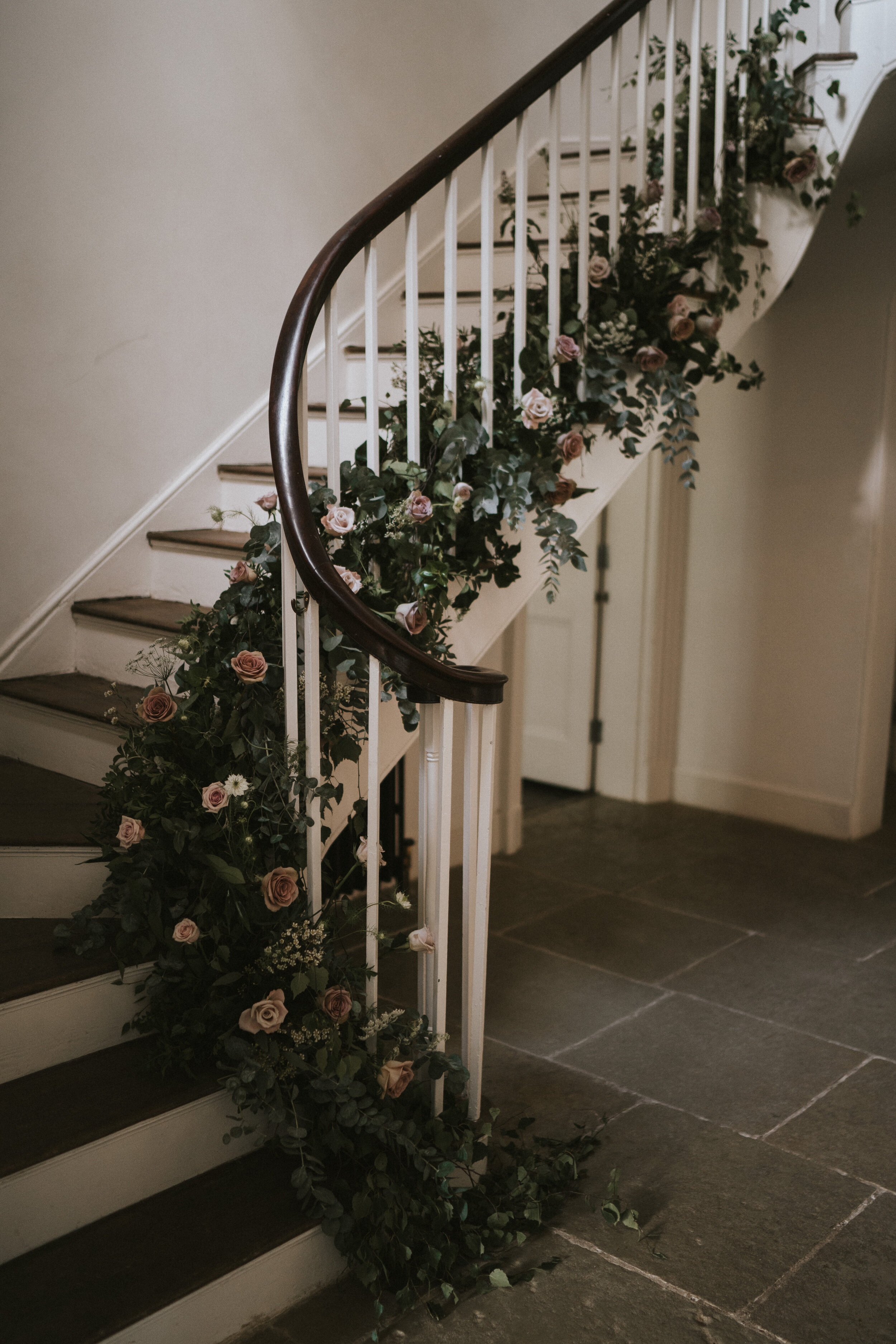  Floral wedding installation of roses and foliage on staircase at Aswarby Rectory, Sleaford, Lincolnshire. 