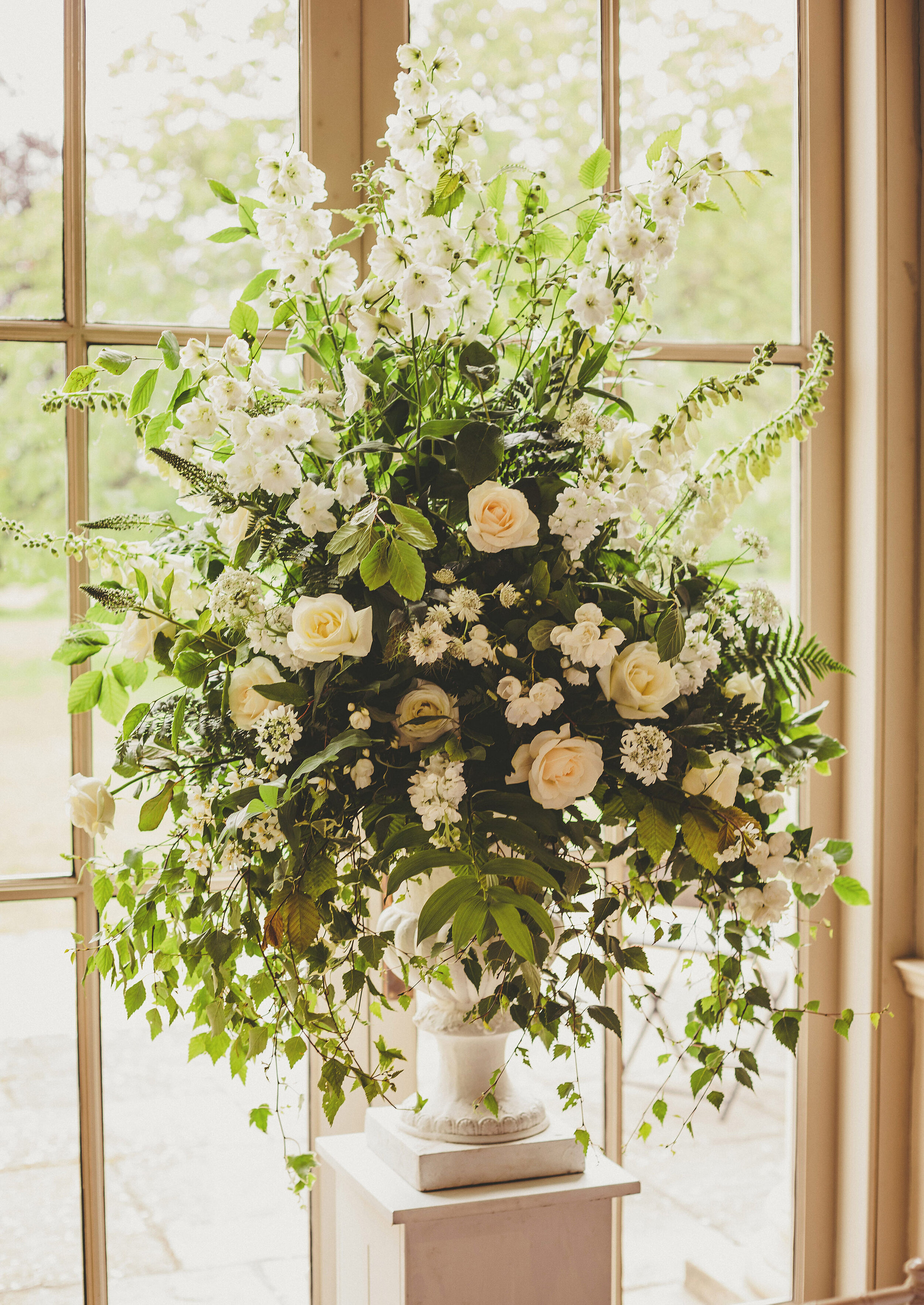  White and green floral pedestal arrangement for wedding by All Bunched Up Florists at Stubton Hall, Newark, Nottinghamshire. 