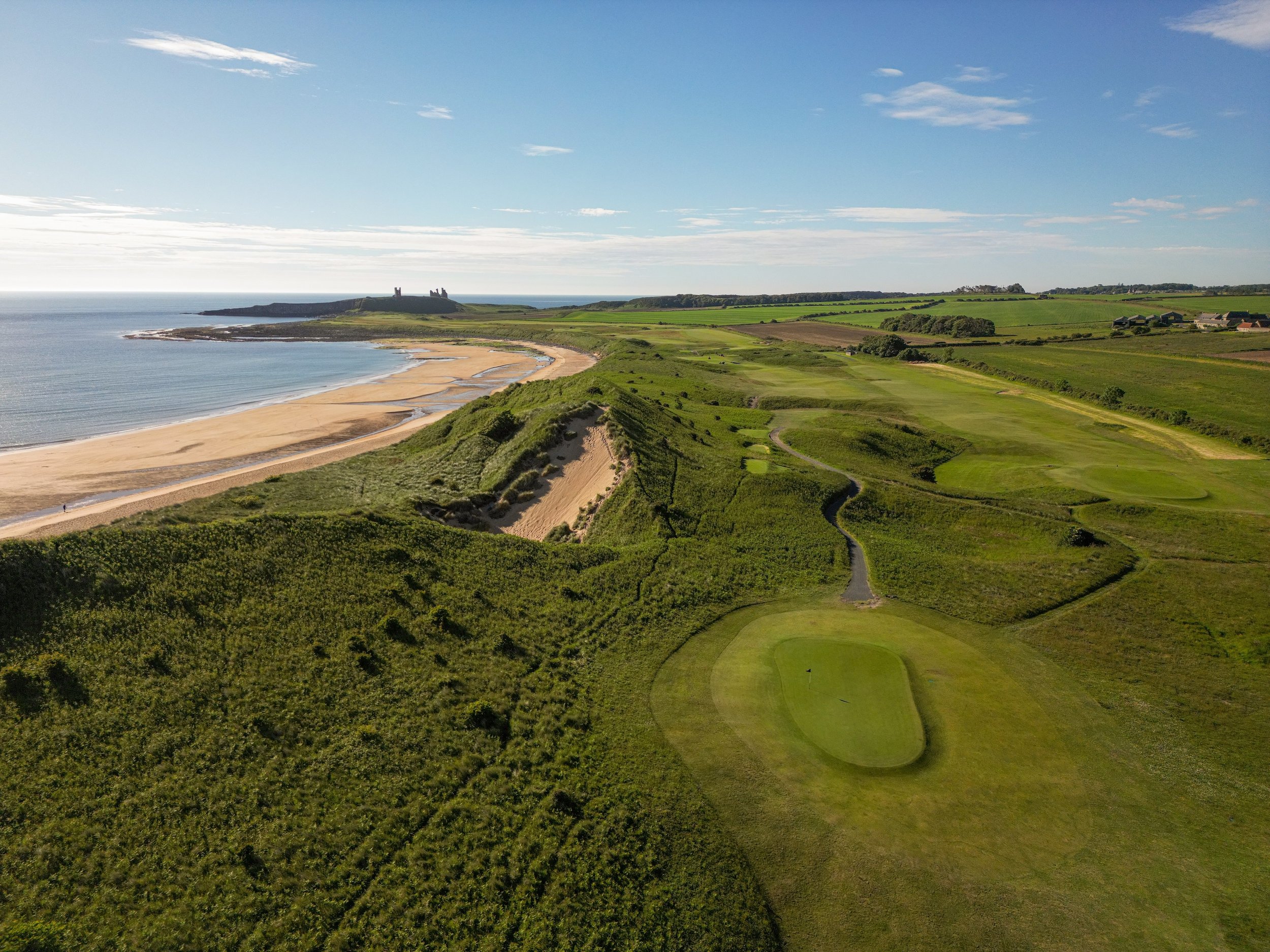 Aerial view of Embleton Bay, the links and Dunstanburgh Castle