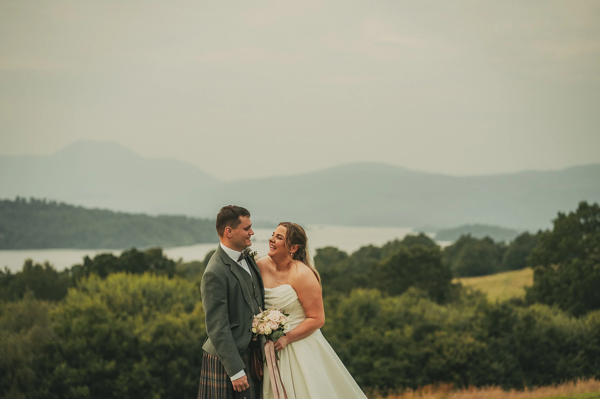 Bride and groom portrait with Loch Lomond behind them at Boturich Castle.
