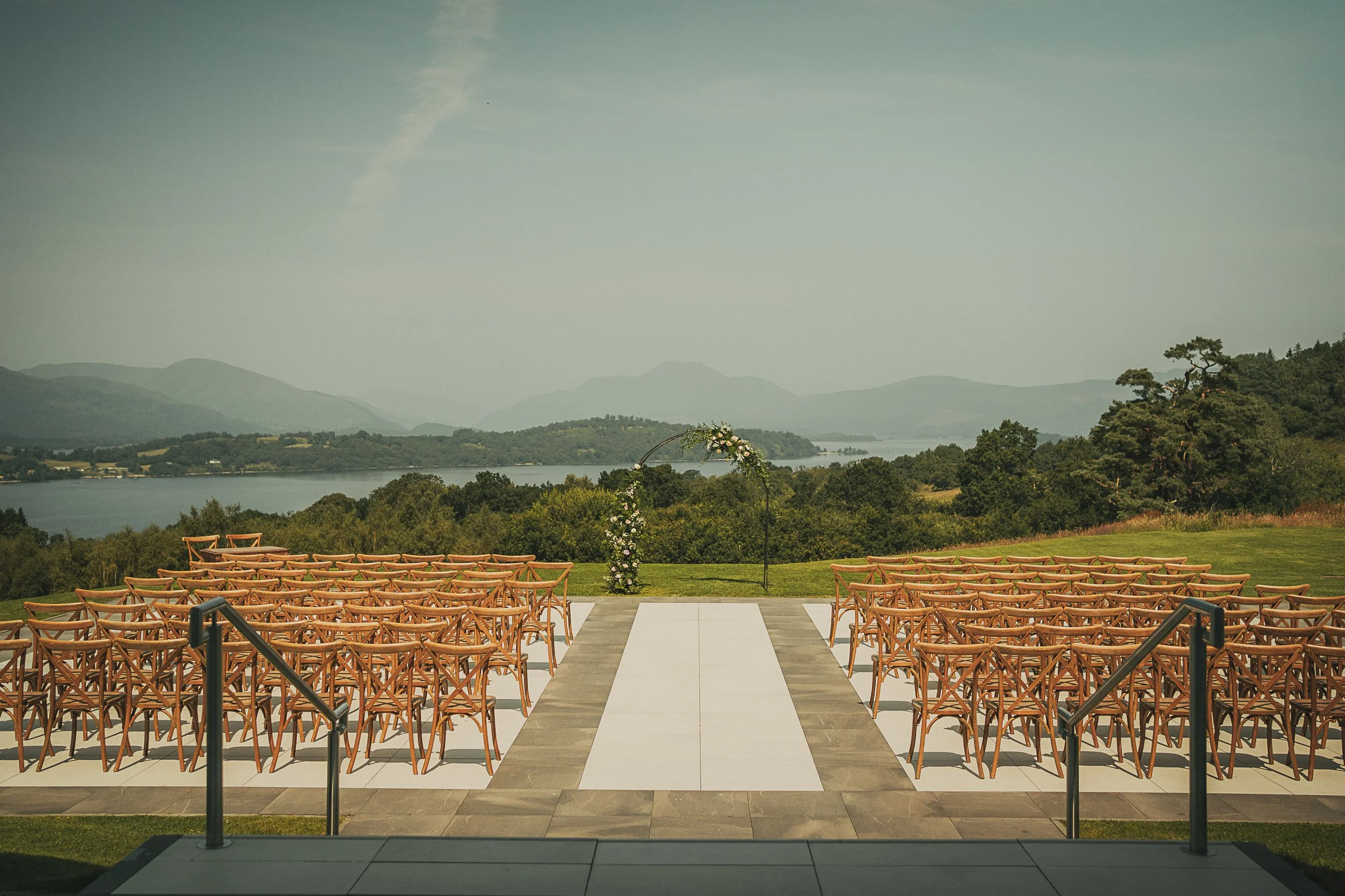 Outdoor wedding ceremony setup at Boturich Castle overlooking Loch Lomond.