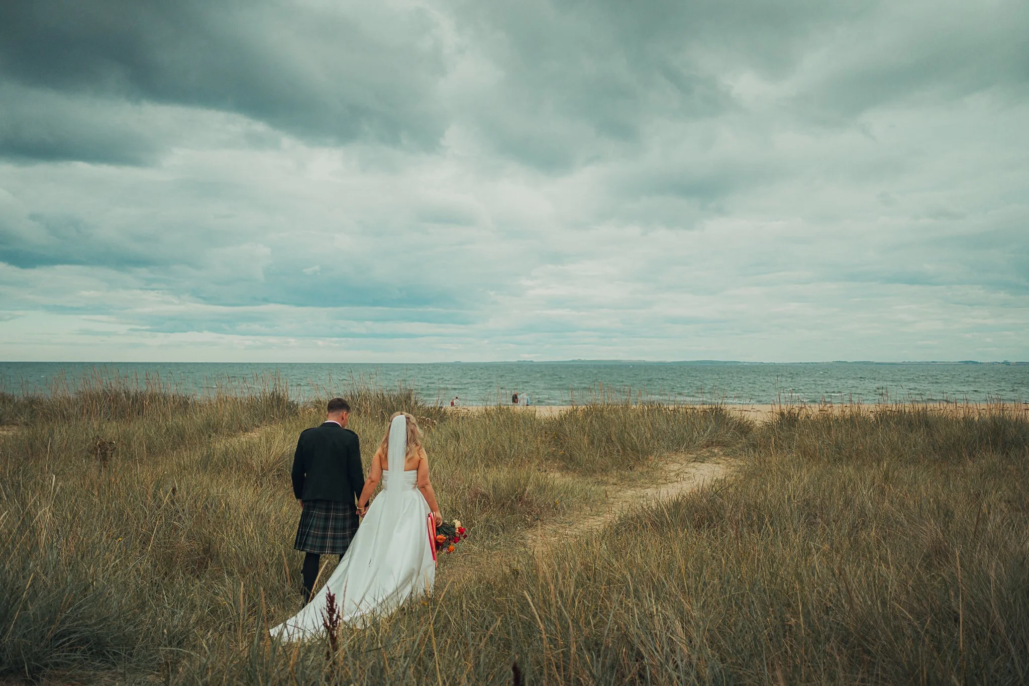 bride-groom-walking-dornoch-beach-highland-wedding.jpg