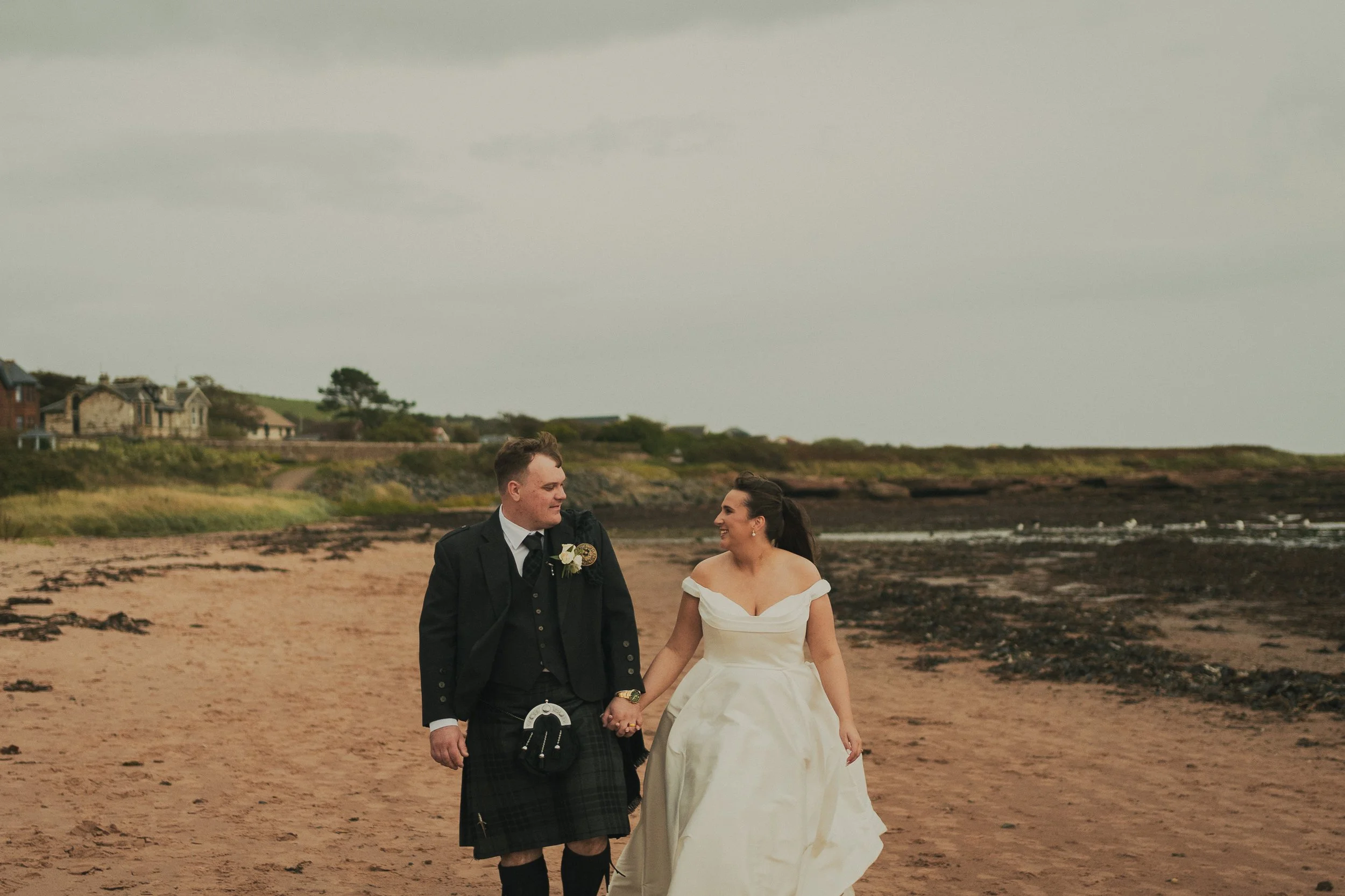 gill-callum-seamill-hydro-wedding-couple-walking-beach.jpg