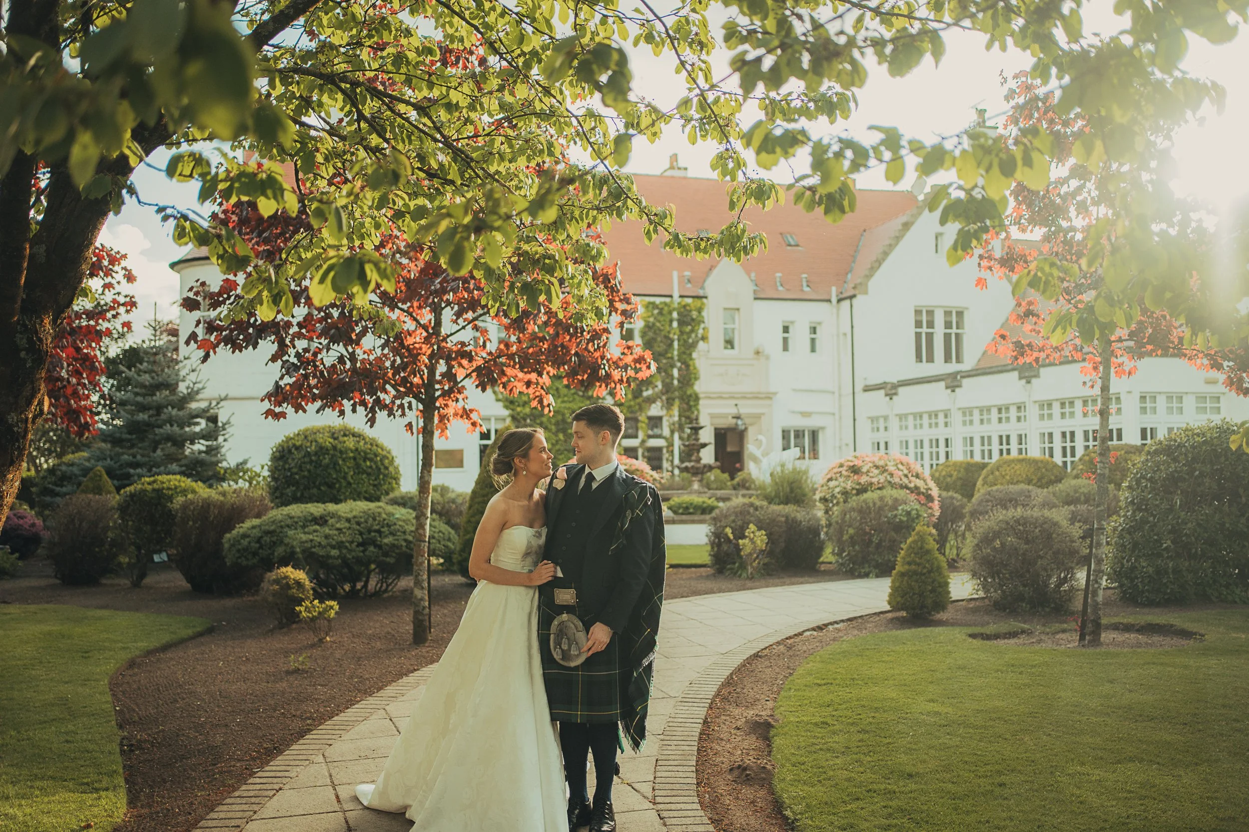 Newly married couple walking through the gardens at Lochgreen House Hotel in Troon.