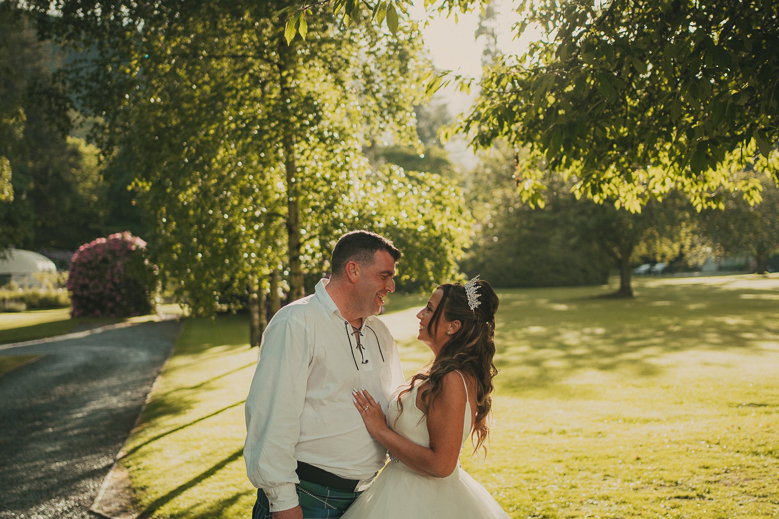 Golden hour portrait of Shona and John in the grounds of Dunkeld House Hotel during their wedding day.