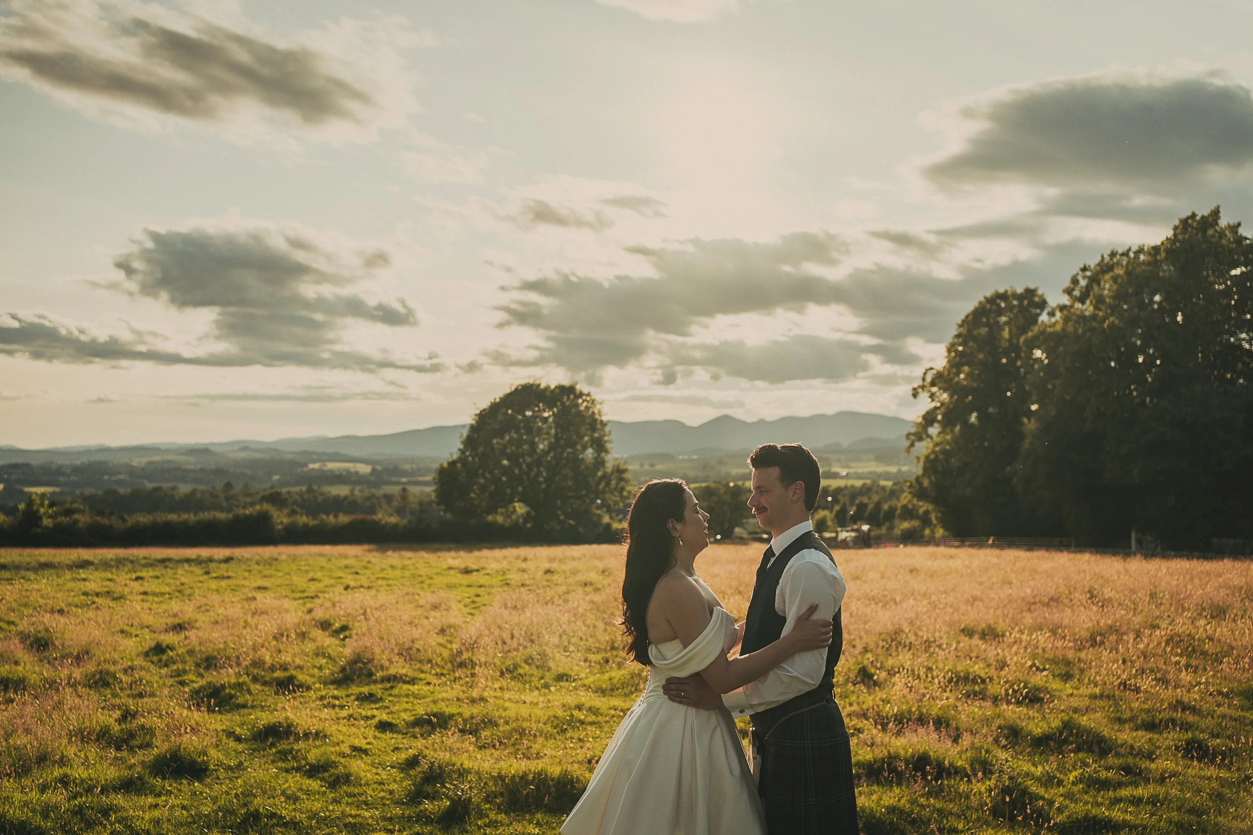 Claire and Adam enjoying a golden hour portrait in the field beside Killearn Village Hall