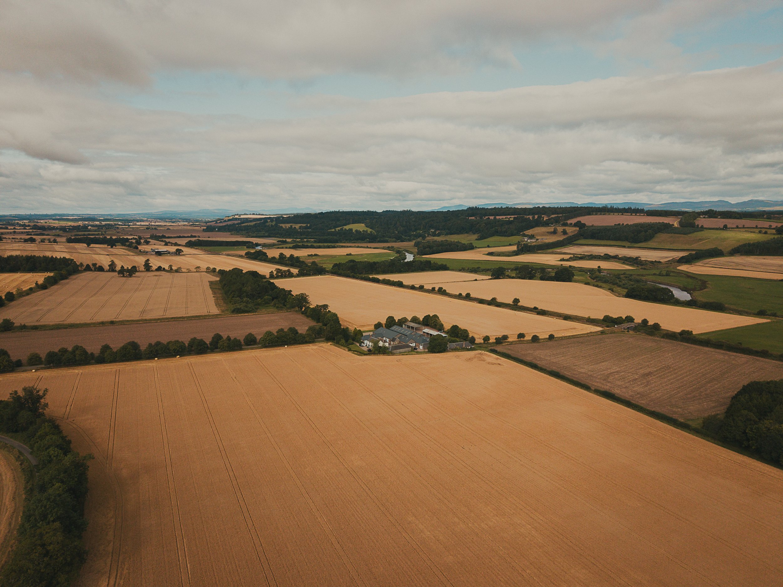 Aerial view of Rossie on the Earn wedding venue surrounded by ripe fields in the Perthshire countryside