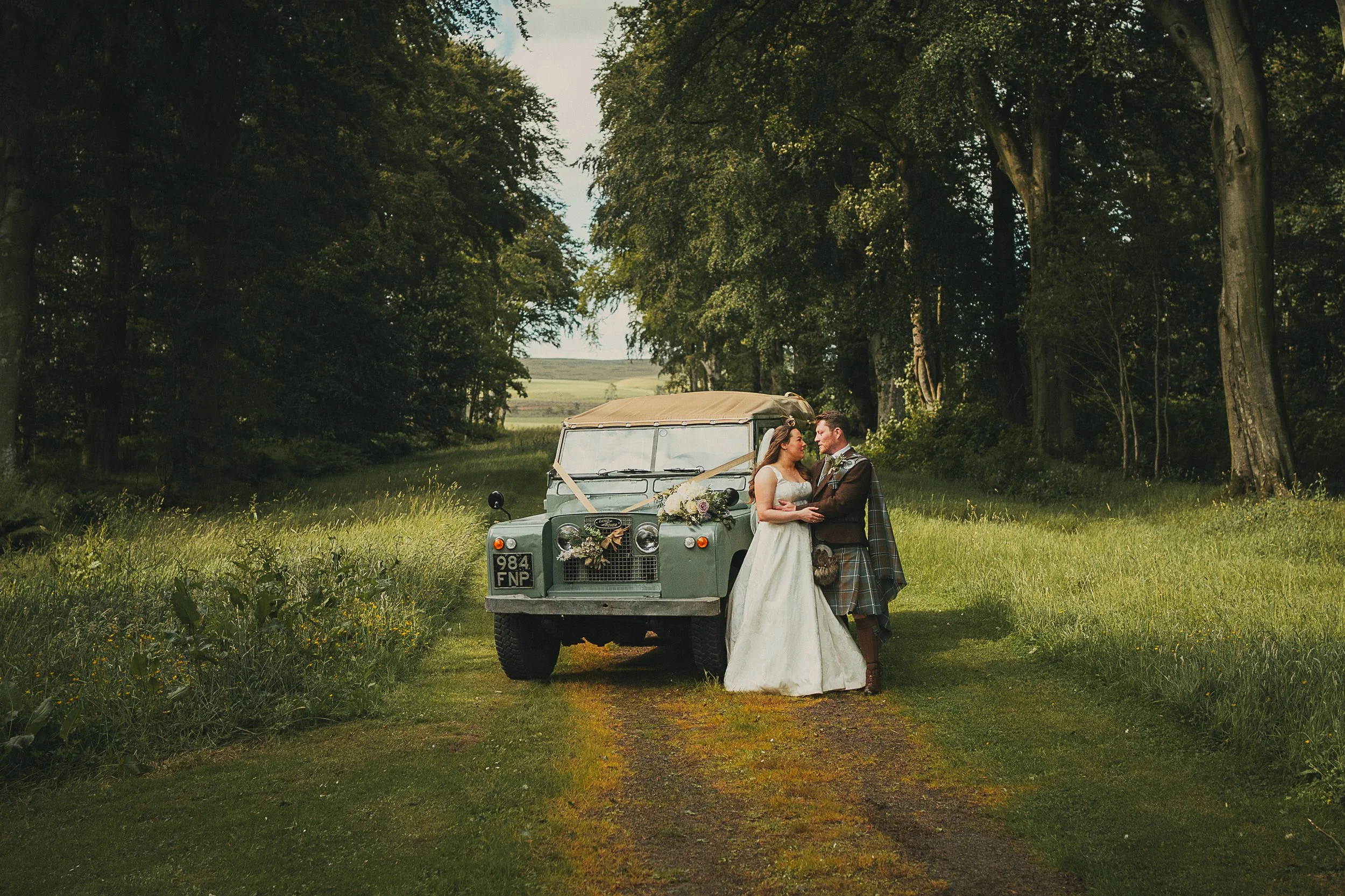 Emily and Peter beside a classic Land Rover after their wedding ceremony at Wedderlie House.