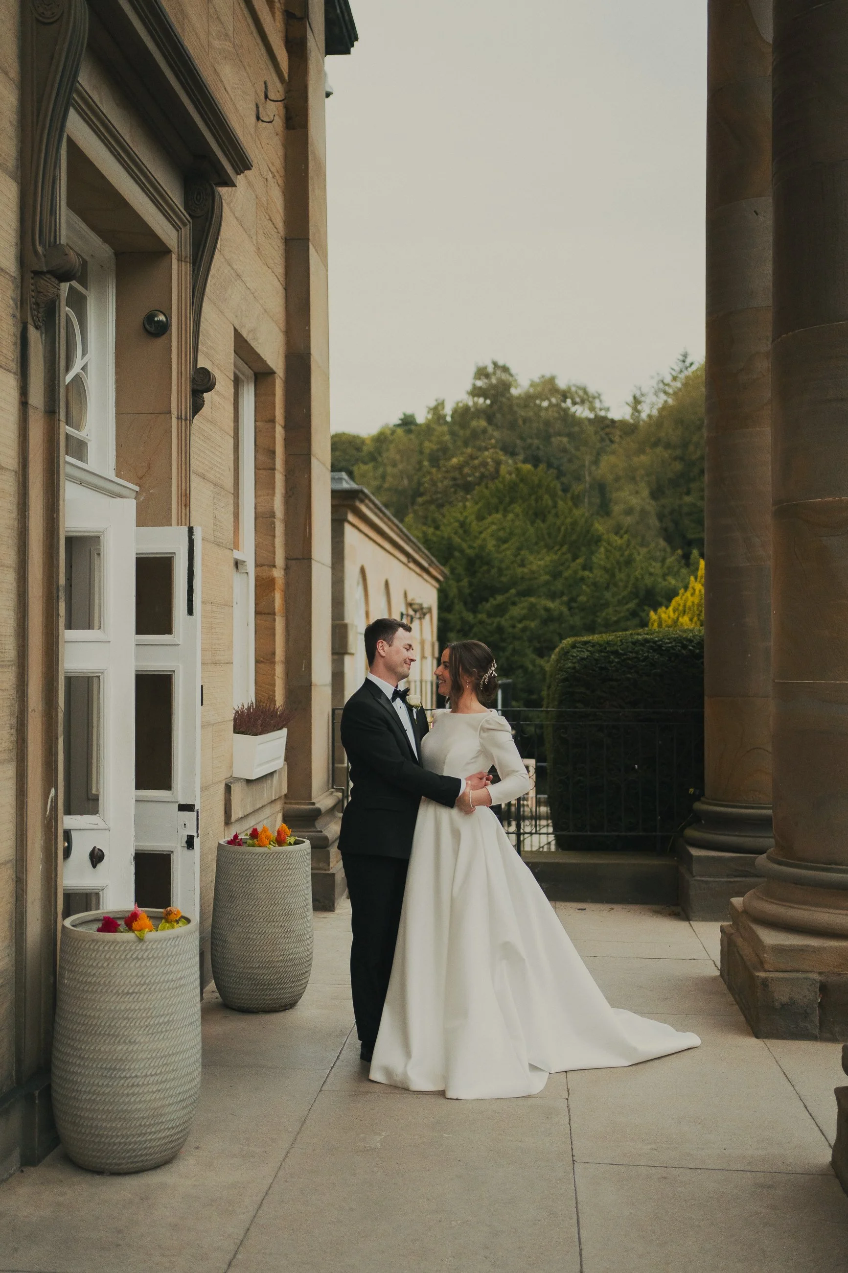 Alyssa and Ian embracing outside Balbirnie House on their wedding day