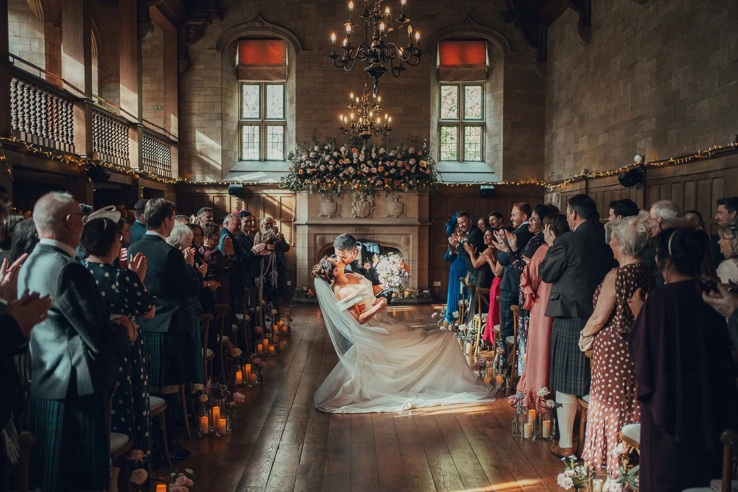 Just married couple celebrating with a kiss dip walking back up the aisle at Achnagairn