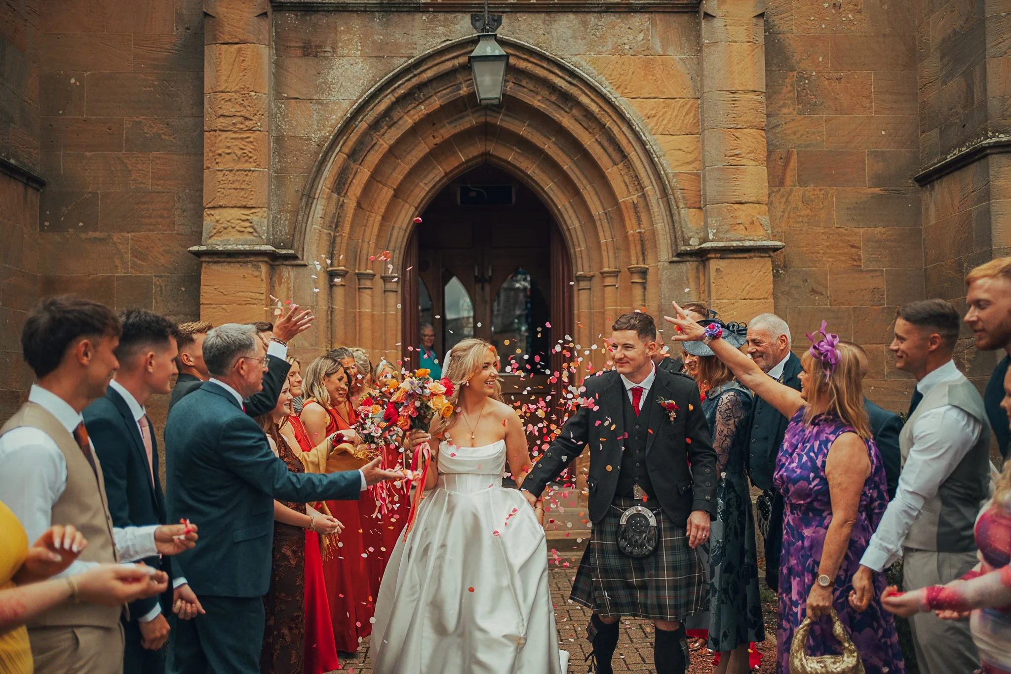 Fun confetti moment outside Dornoch Cathedral at Daisy and Steven’s Highland wedding