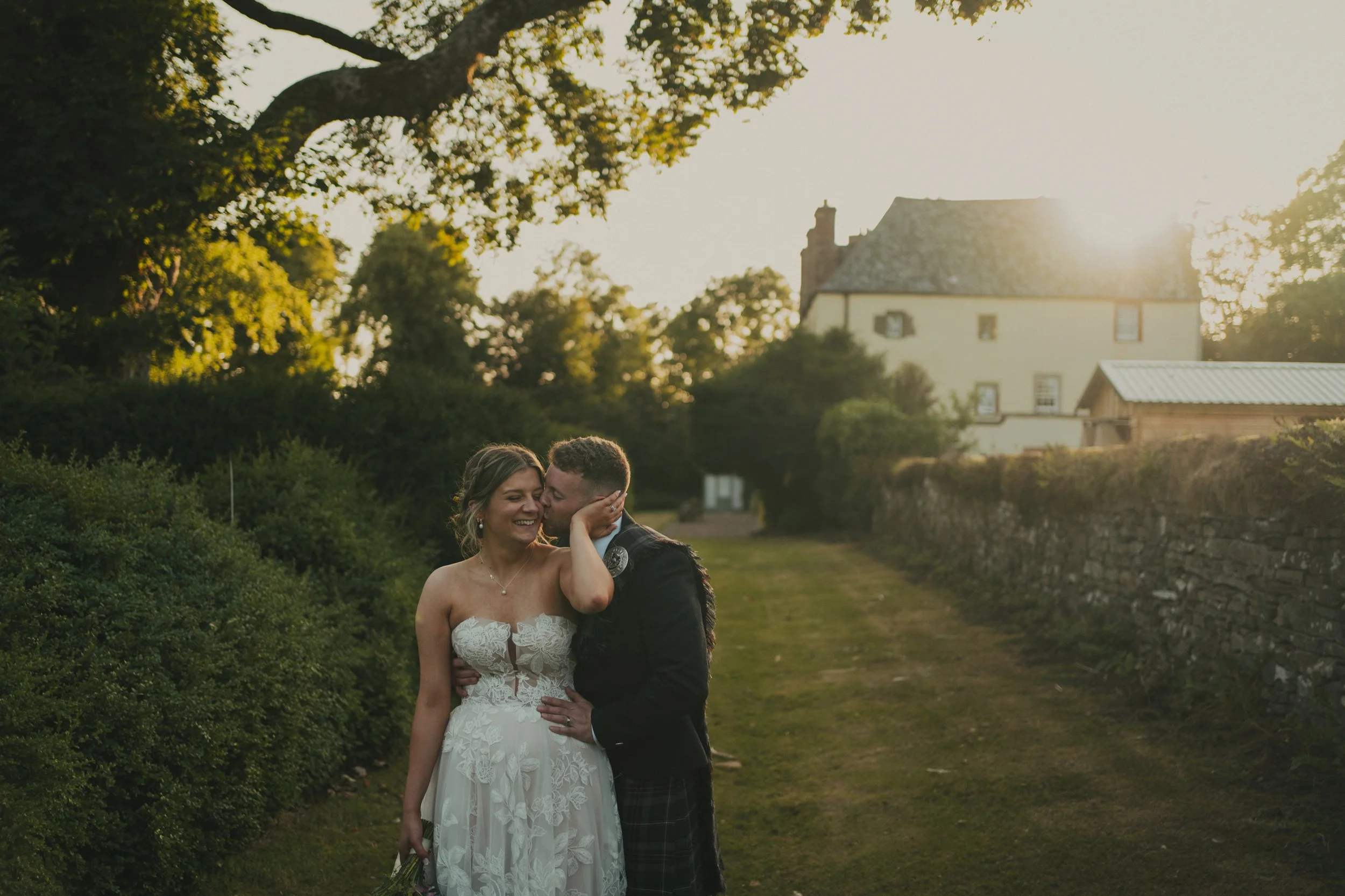 Ryan kissing Bryony on the cheek as they watch the sunset at Wedderlie House