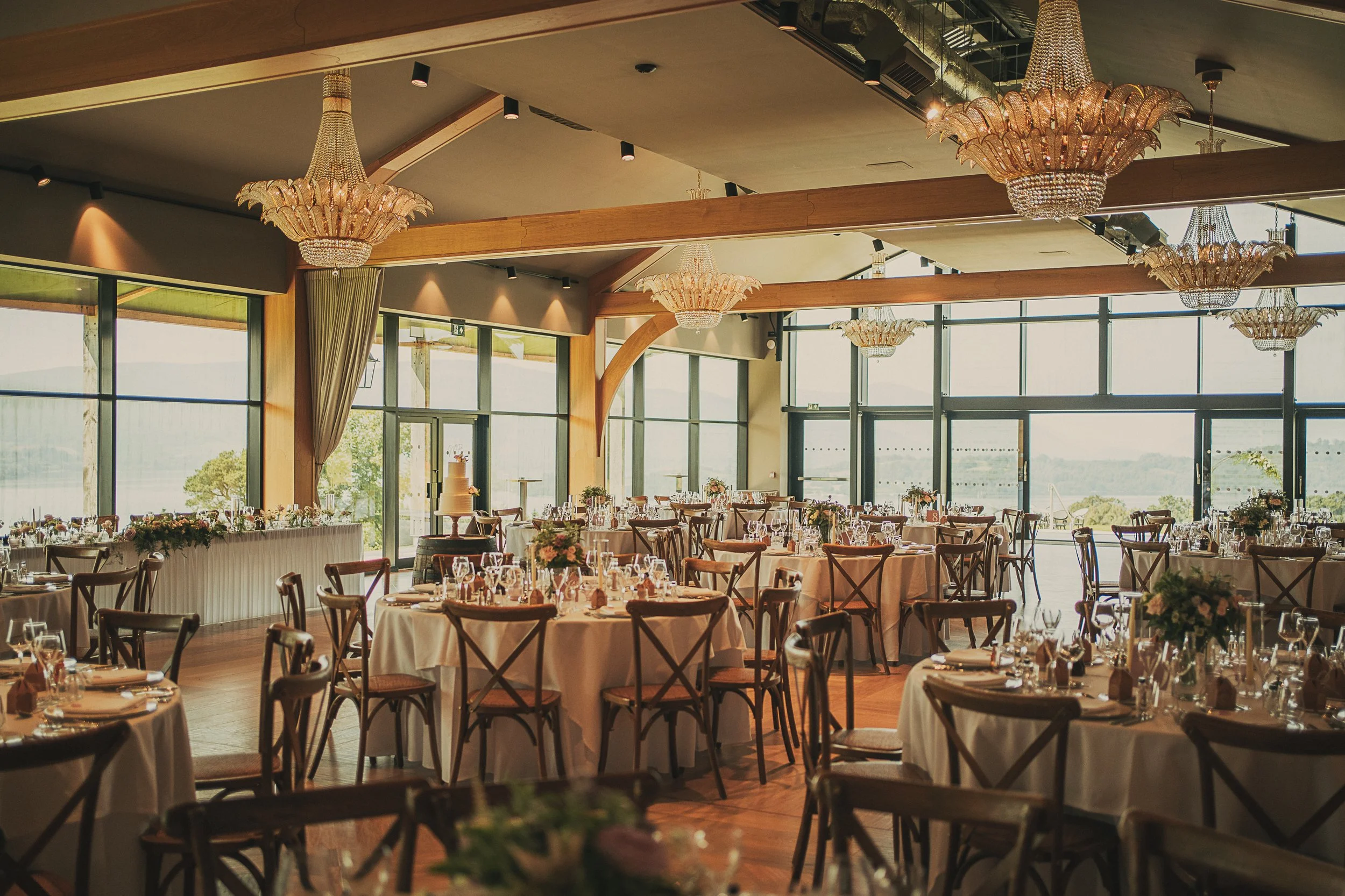 Elegant wedding reception tables with chandeliers inside Boturich Castle.