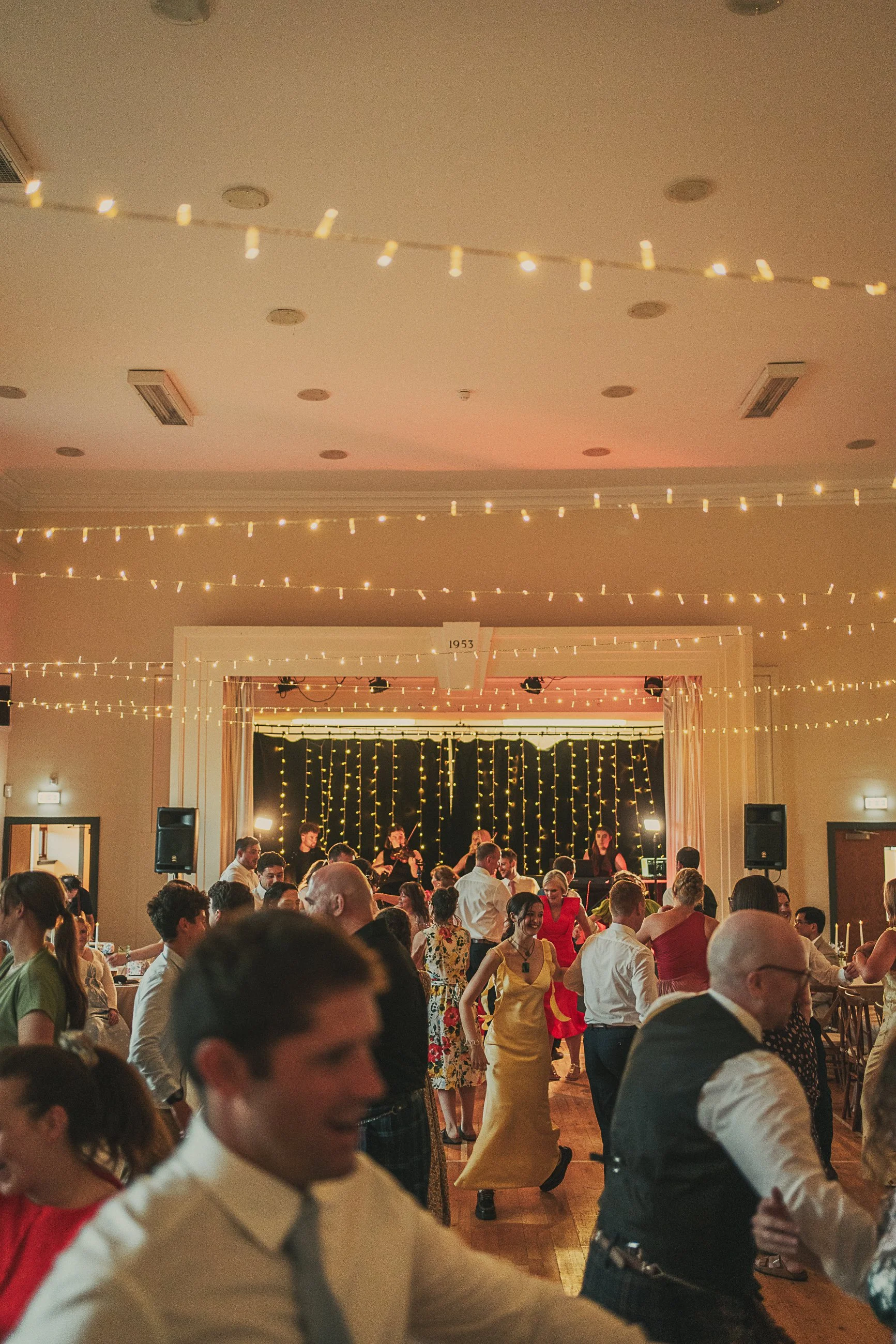 Wedding guests enjoying ceilidh dancing at Claire and Adam's reception in Killearn Village Hall