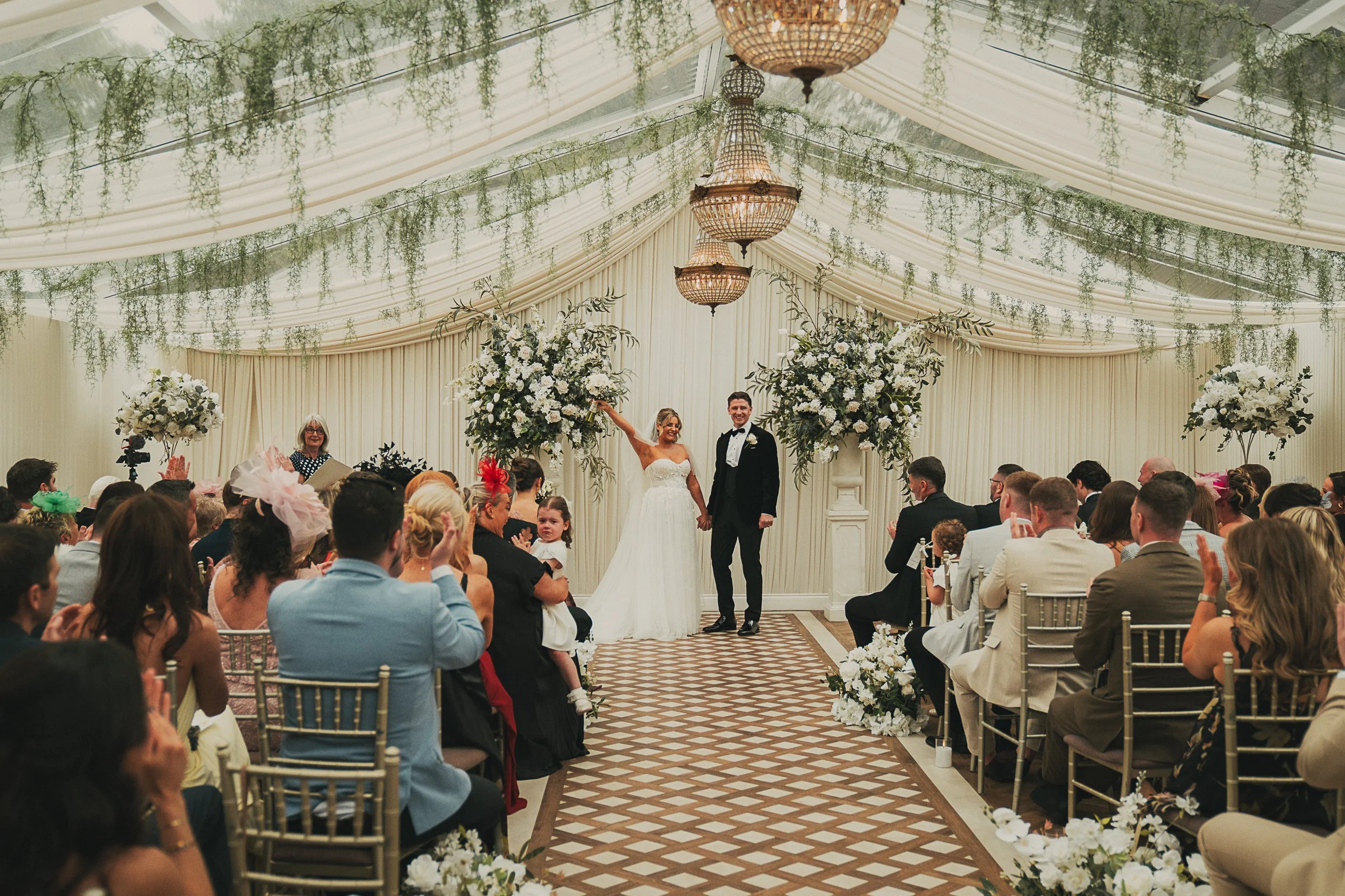 Emma and Frazer celebrating as newlyweds at the top of the aisle after their ceremony at Cornhill Castle.