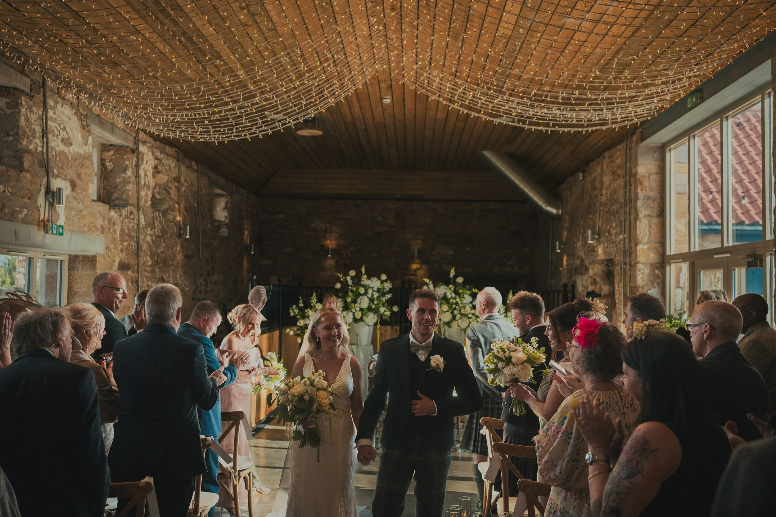 Robyn and Robbie walking back down the aisle after their wedding ceremony at Falside Mill