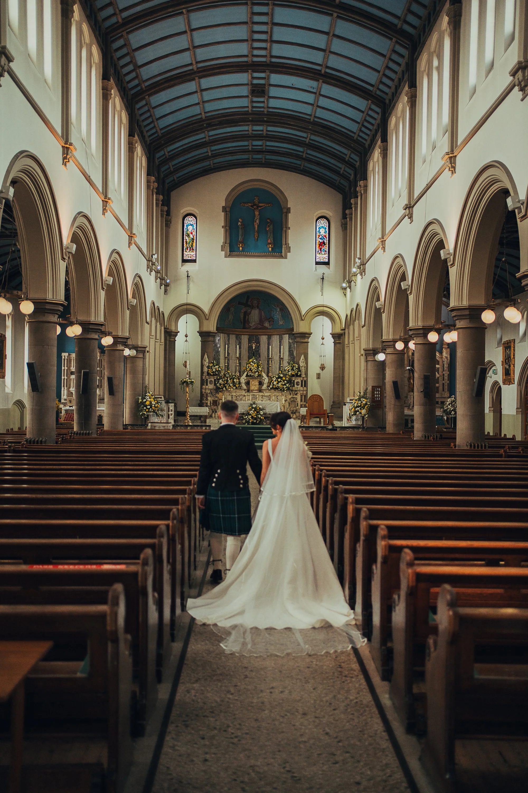 Bride and groom standing together in the aisle during ceremony at Holy Cross Parish Church Glasgow