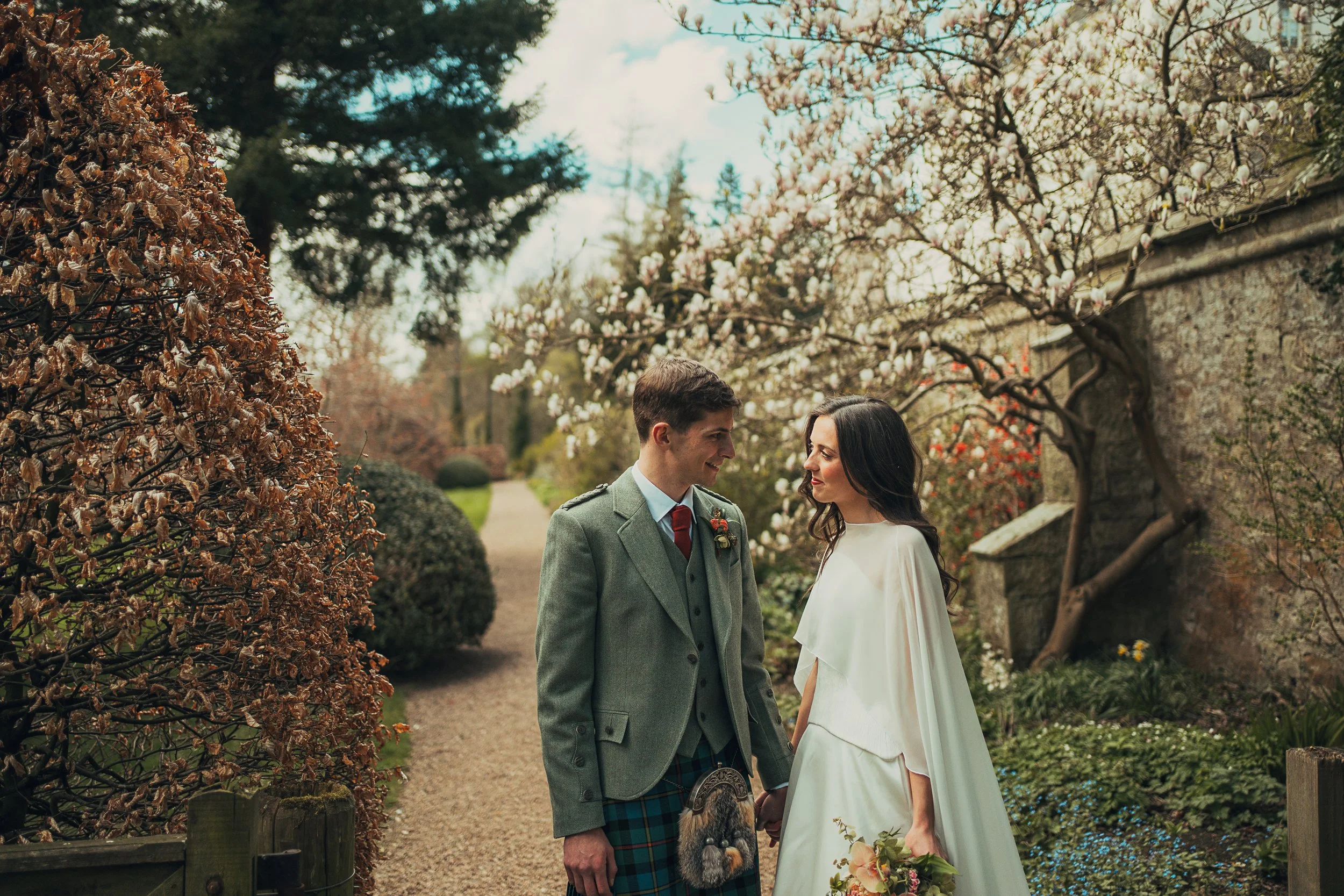 Bride and groom looking at each other in the walled garden at Winton Castle, East Lothian