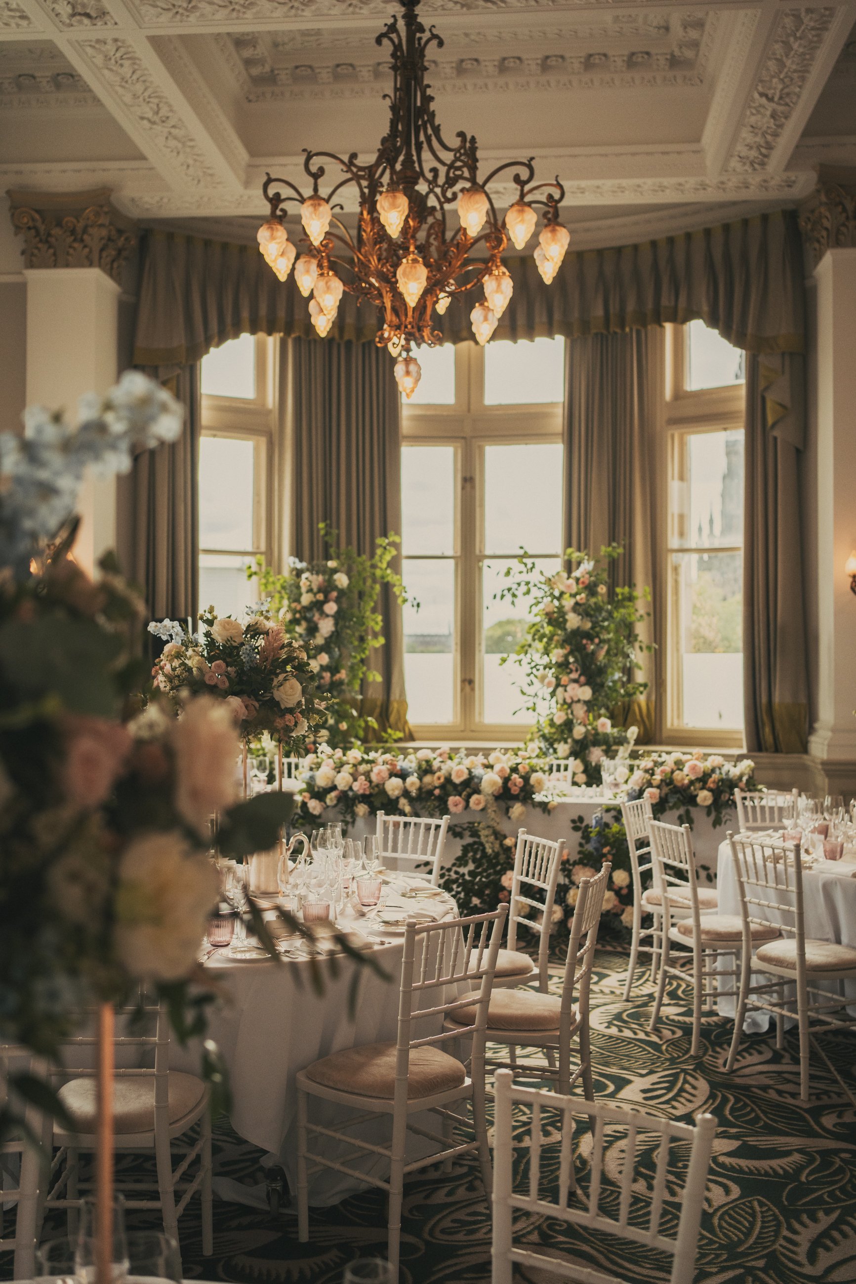 Elegant wedding reception table setup beneath a chandelier at The Balmoral Hotel Edinburgh