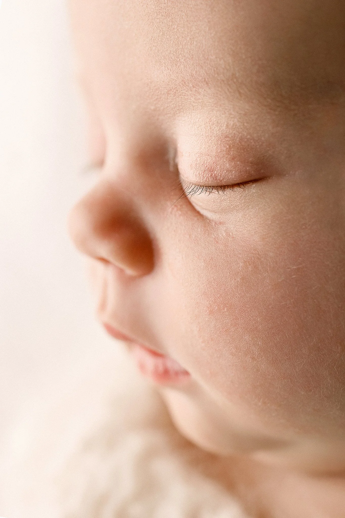 Close-up of a sleeping baby's face with closed eyes, soft skin, and gentle expression.