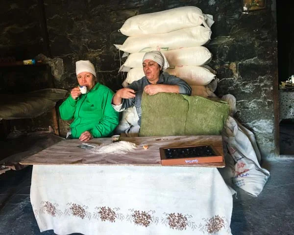 At first I thought we were going to annoy these lavash-baking ladies by getting in the way. But they were not only gracious with information, they kept feeding us and serving us soorj , Armenian coffee. That's a box of chocolates on the table. One of the women is fixing the batat, the pillow-like thing they use to stick the lavash to the walls of the tonir with a firm whomp .